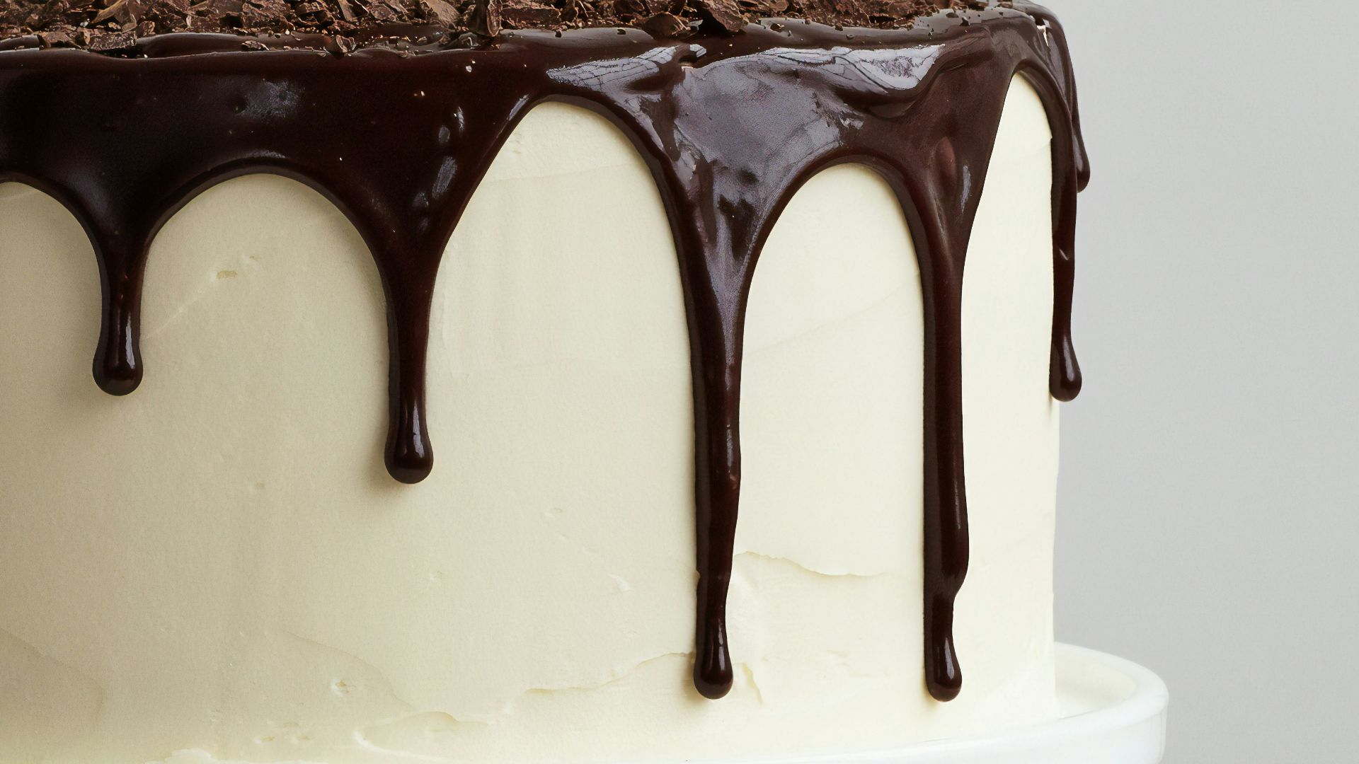 white cake with chocolate syrup on white ceramic plate