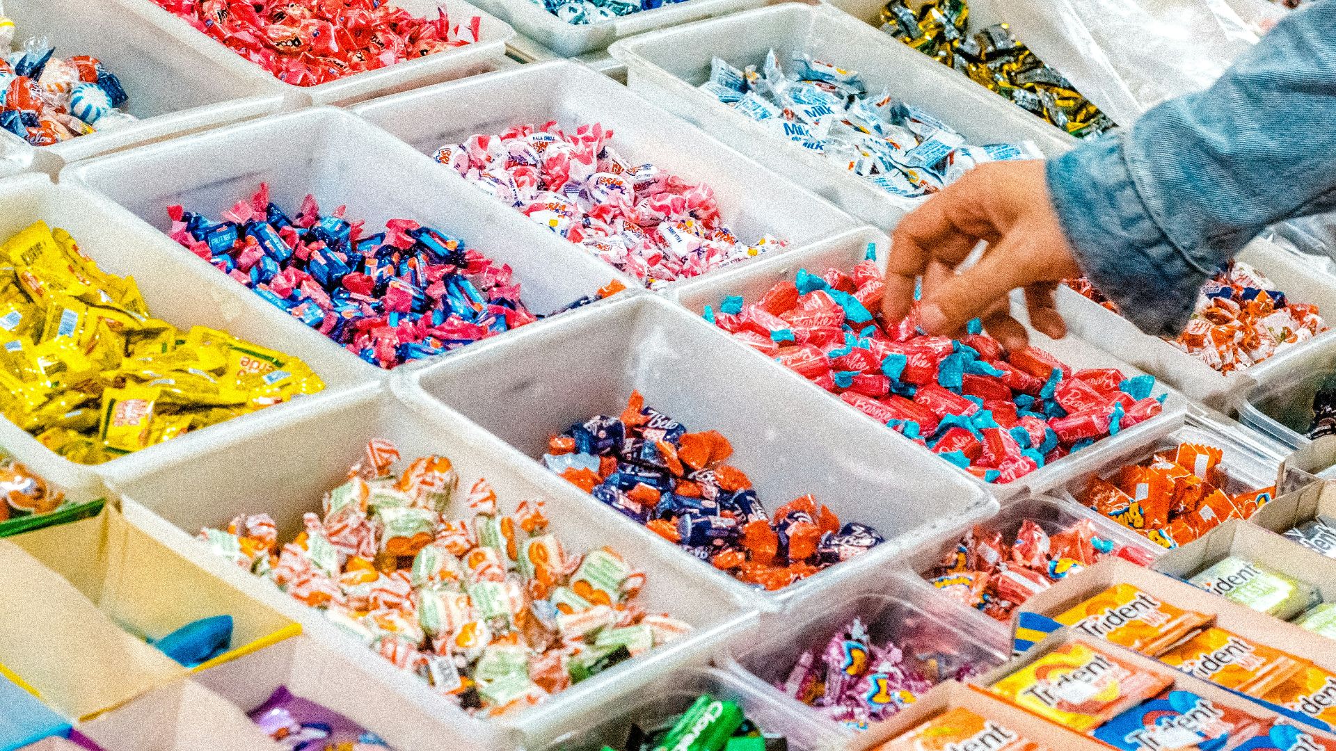 person holding a candy pack on white plastic box