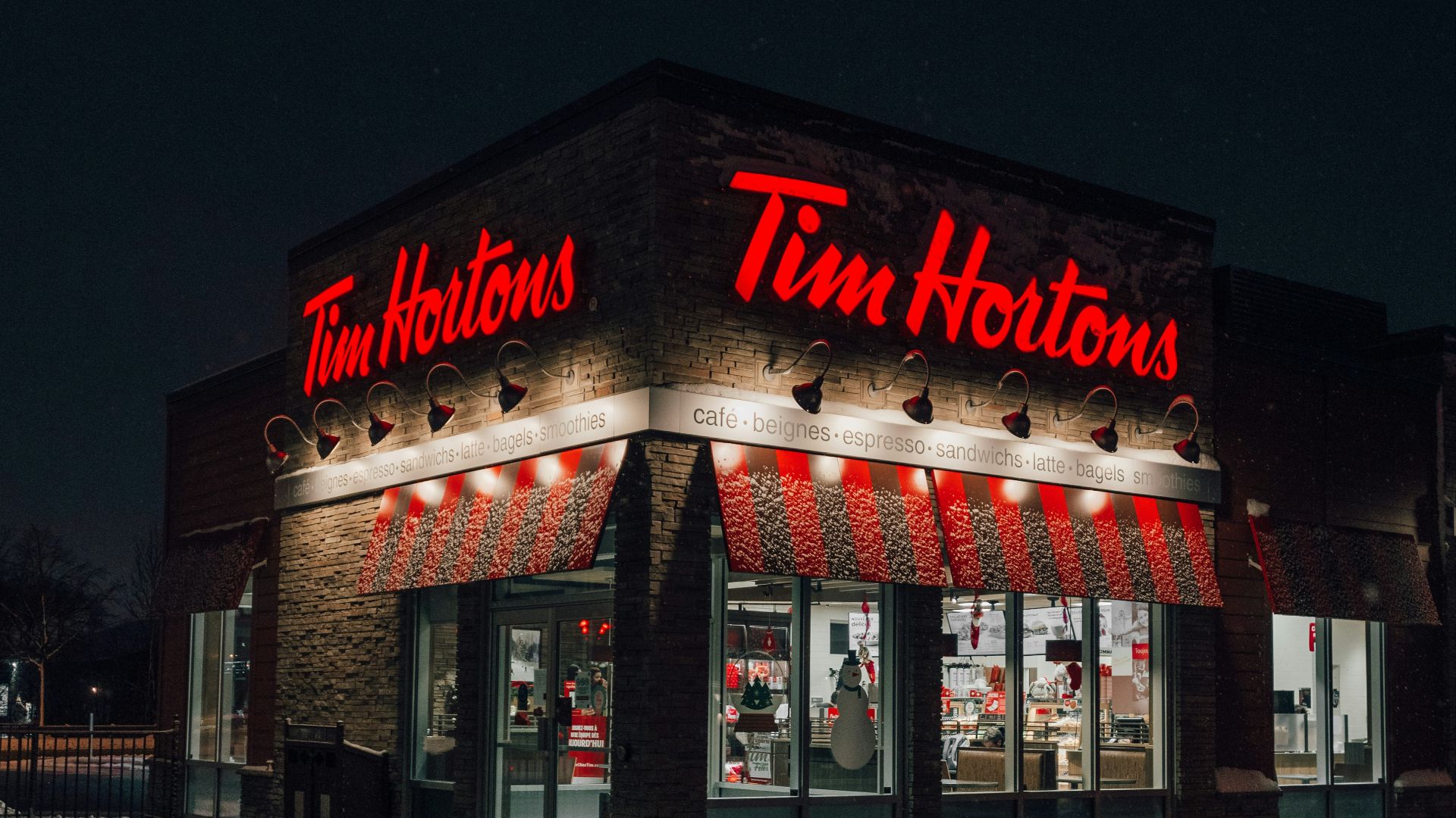 a tim hortons store lit up at night