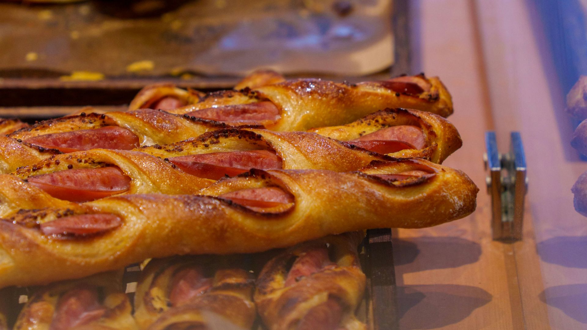 Pastries with sausage are displayed in a shop.