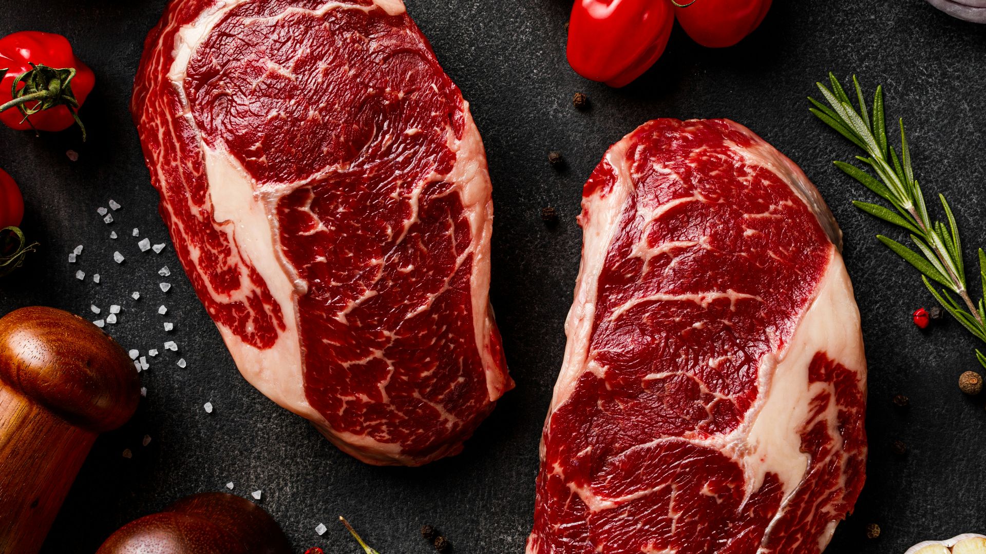 a couple of steaks sitting on top of a table
