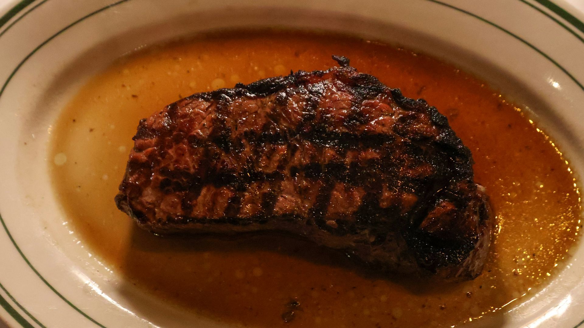 A piece of steak on a plate with sauce