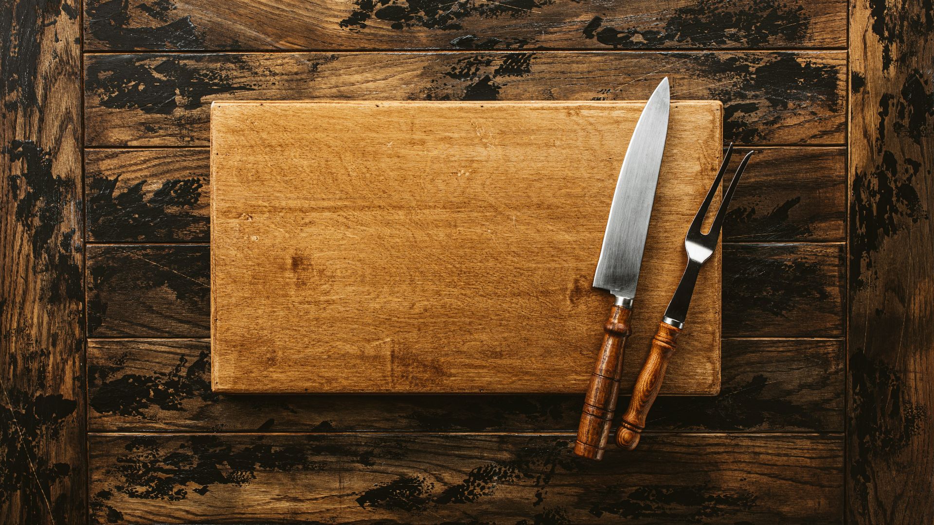 a knife and a board on a wooden surface