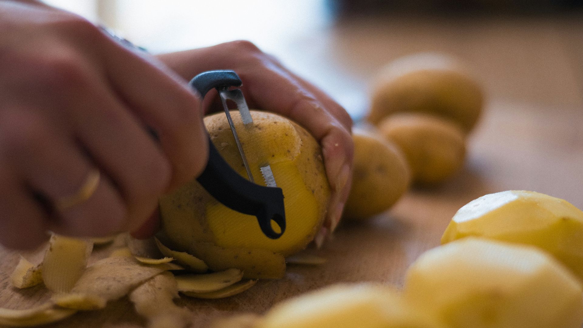 A person peeling a lemon with a pair of scissors