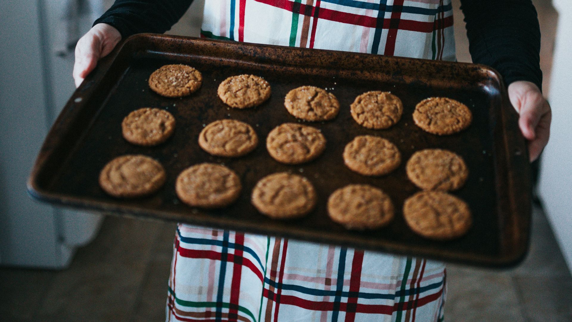 woman in black cardigan holding chocolate cake