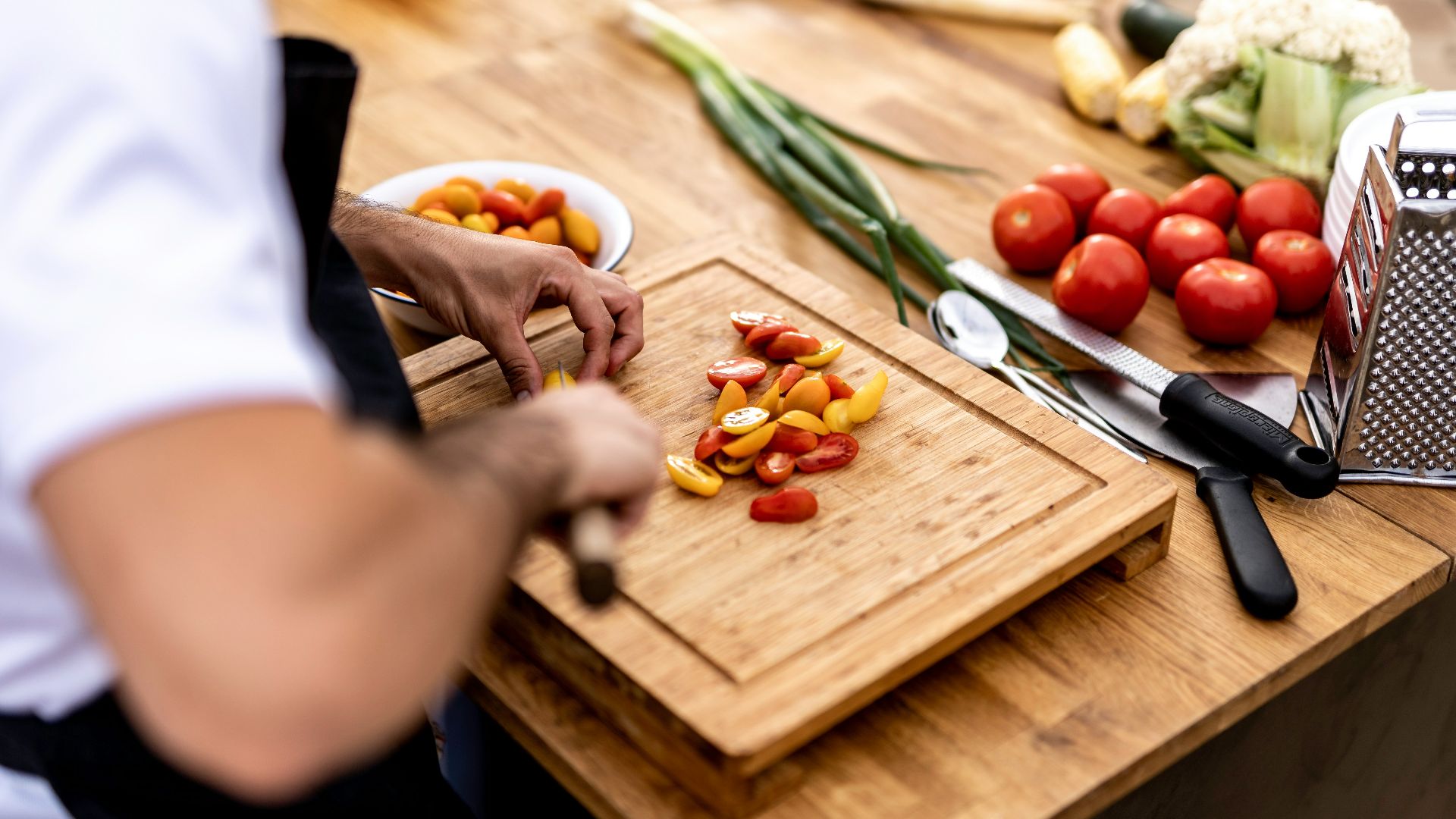 a person cutting up vegetables on a cutting board