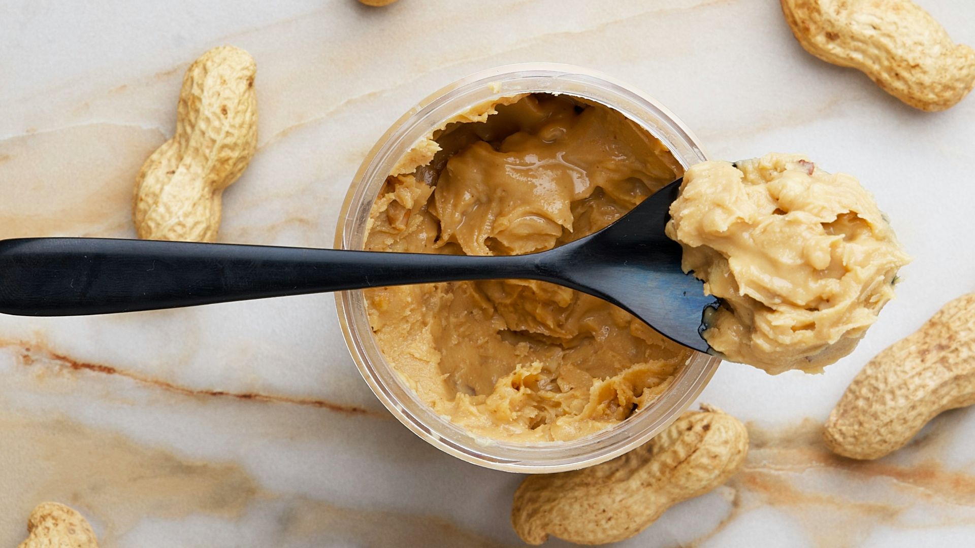 peanut butter with black spoon