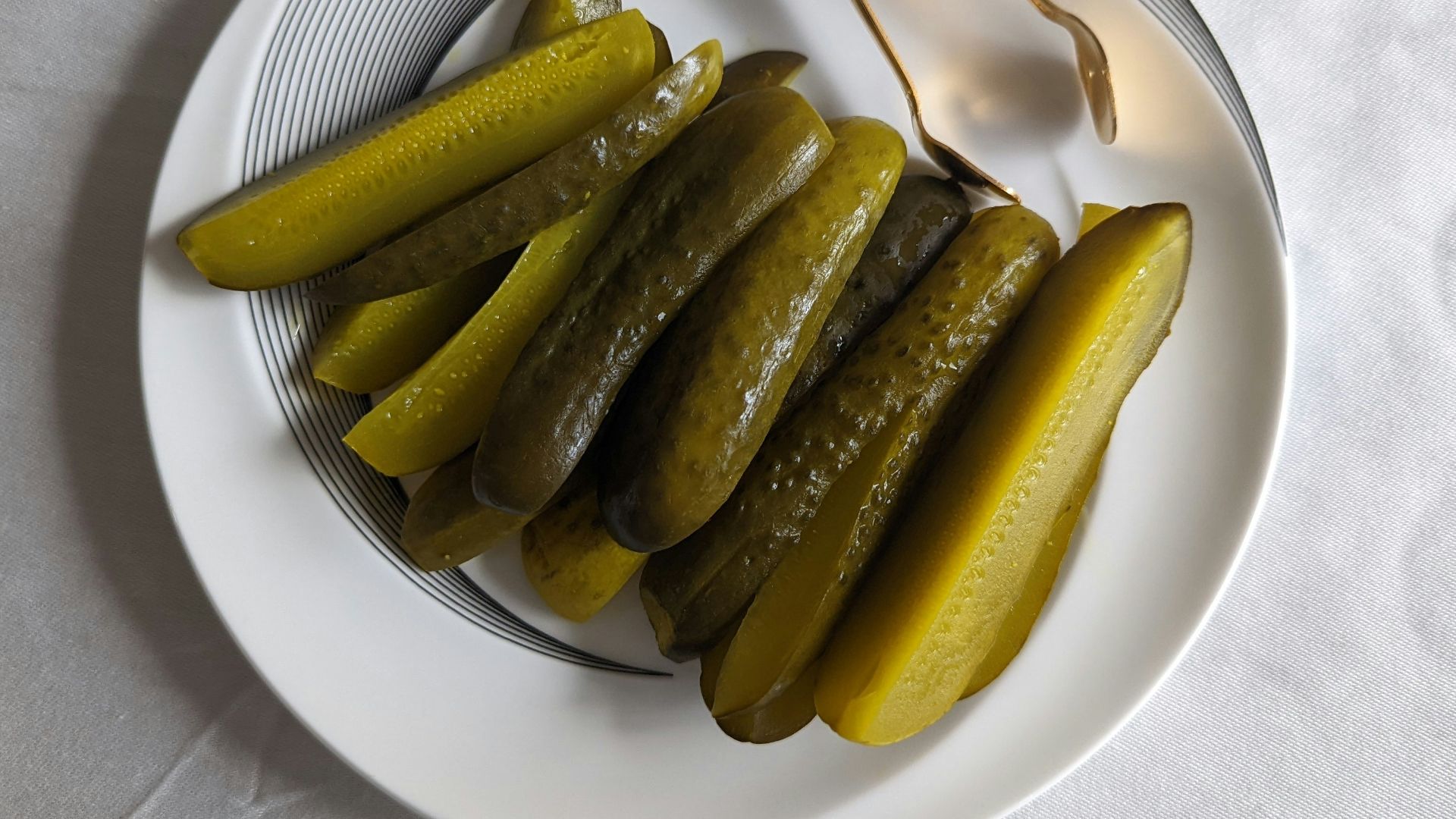 a white plate topped with pickles next to a fork