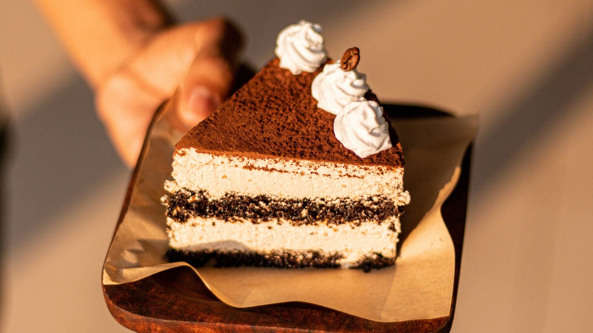 a person holding a piece of cake on a plate