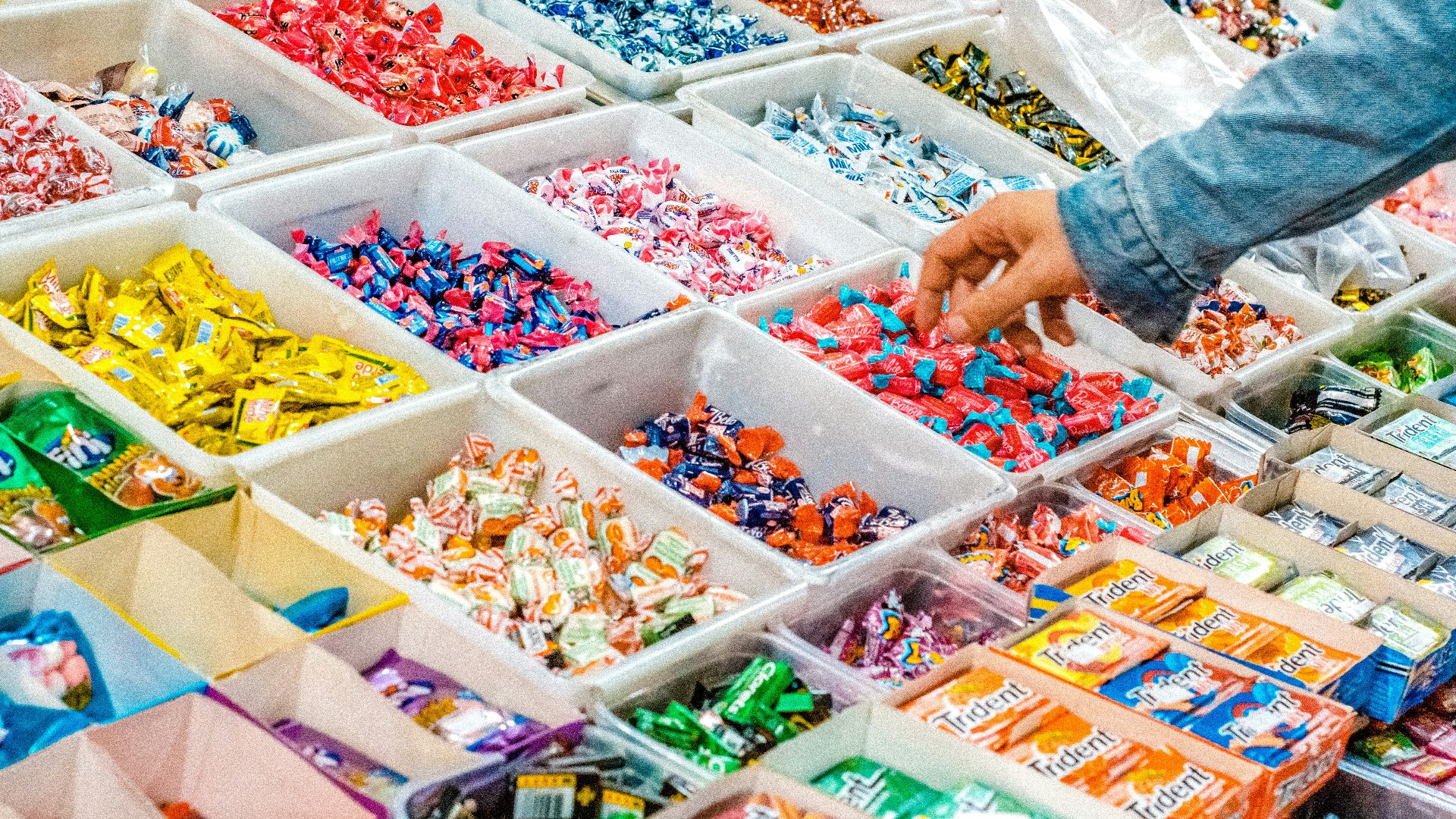 person holding a candy pack on white plastic box