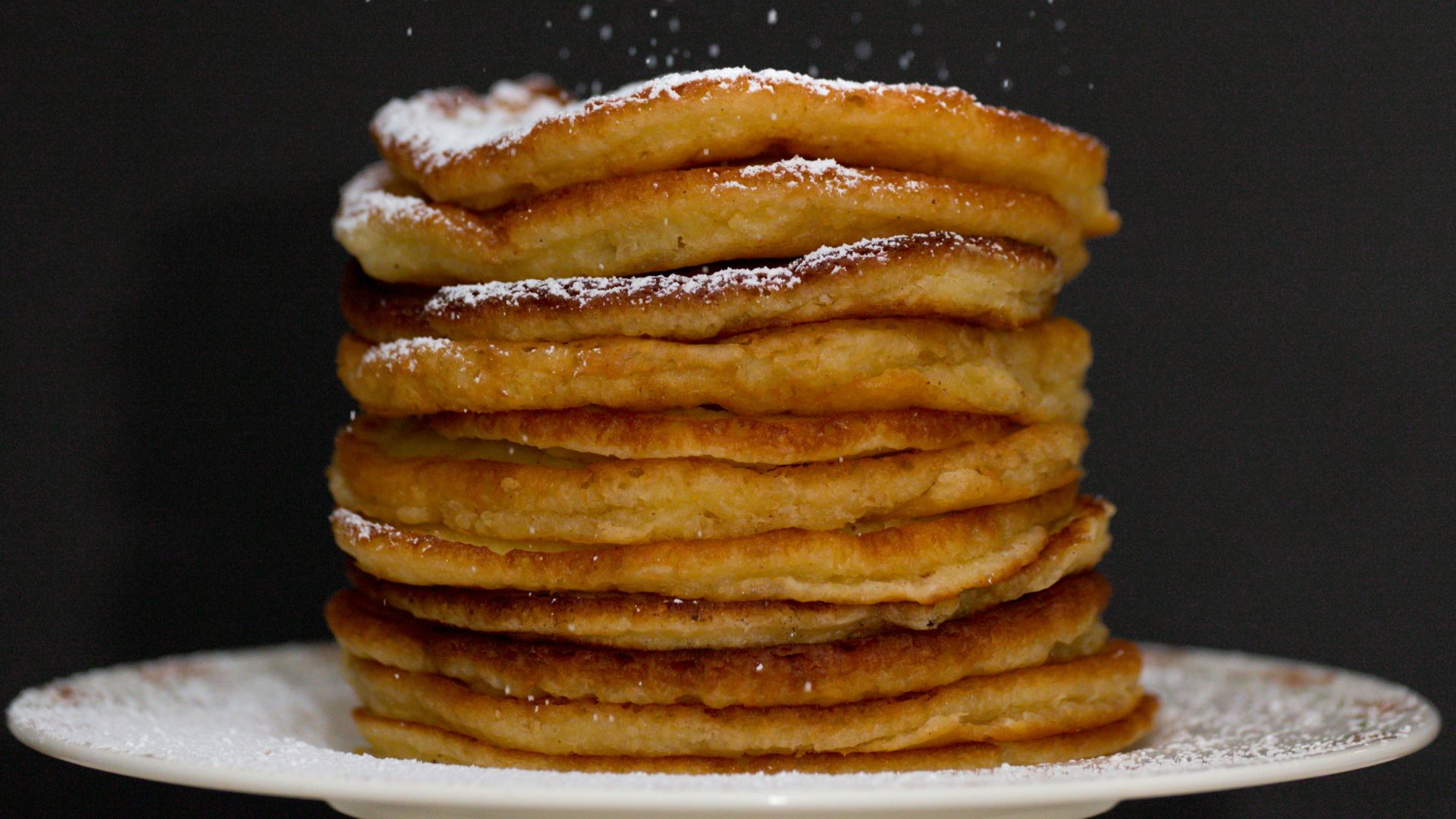 a stack of pancakes covered in powdered sugar