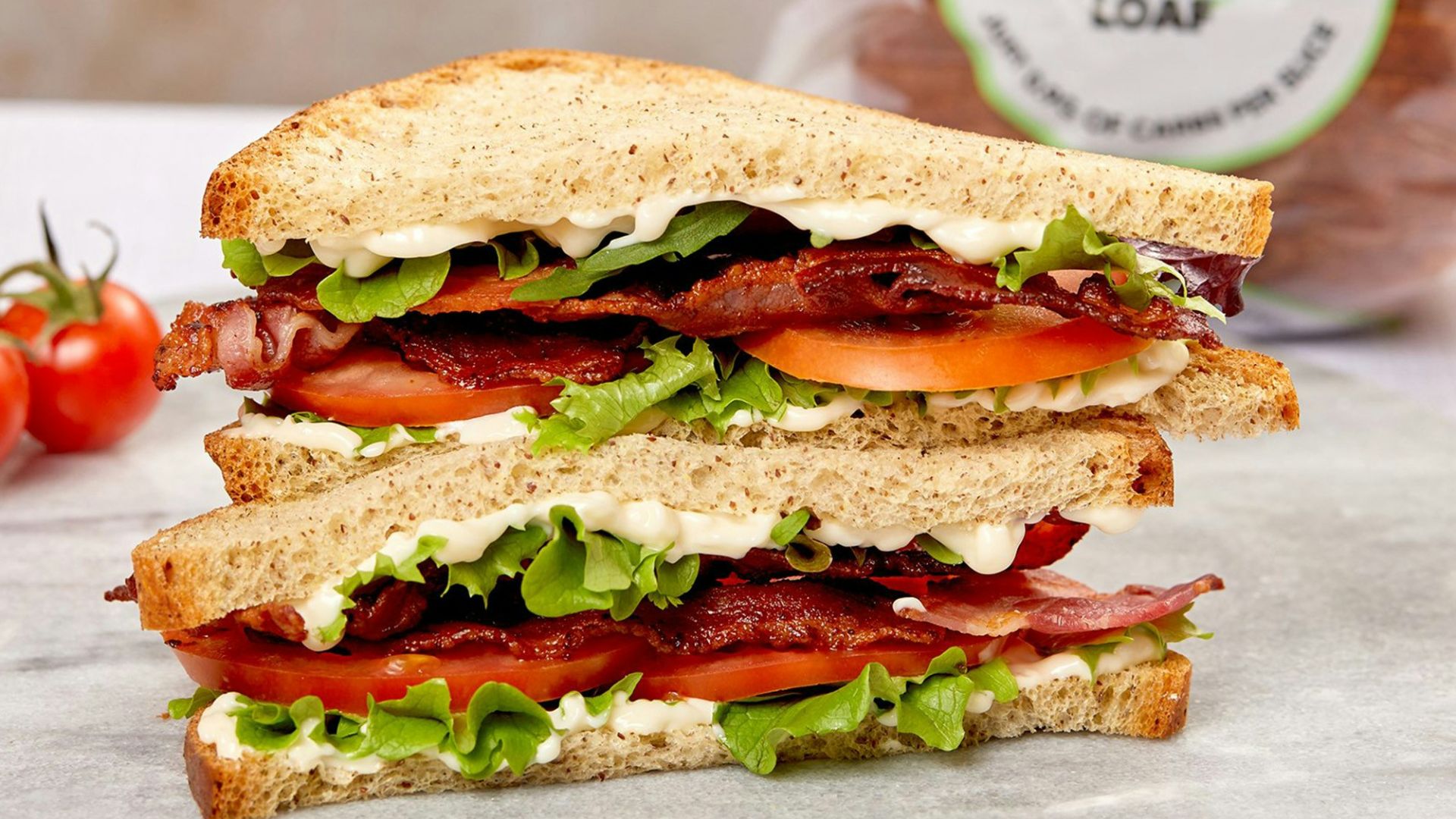 burger with tomato and lettuce on white ceramic plate