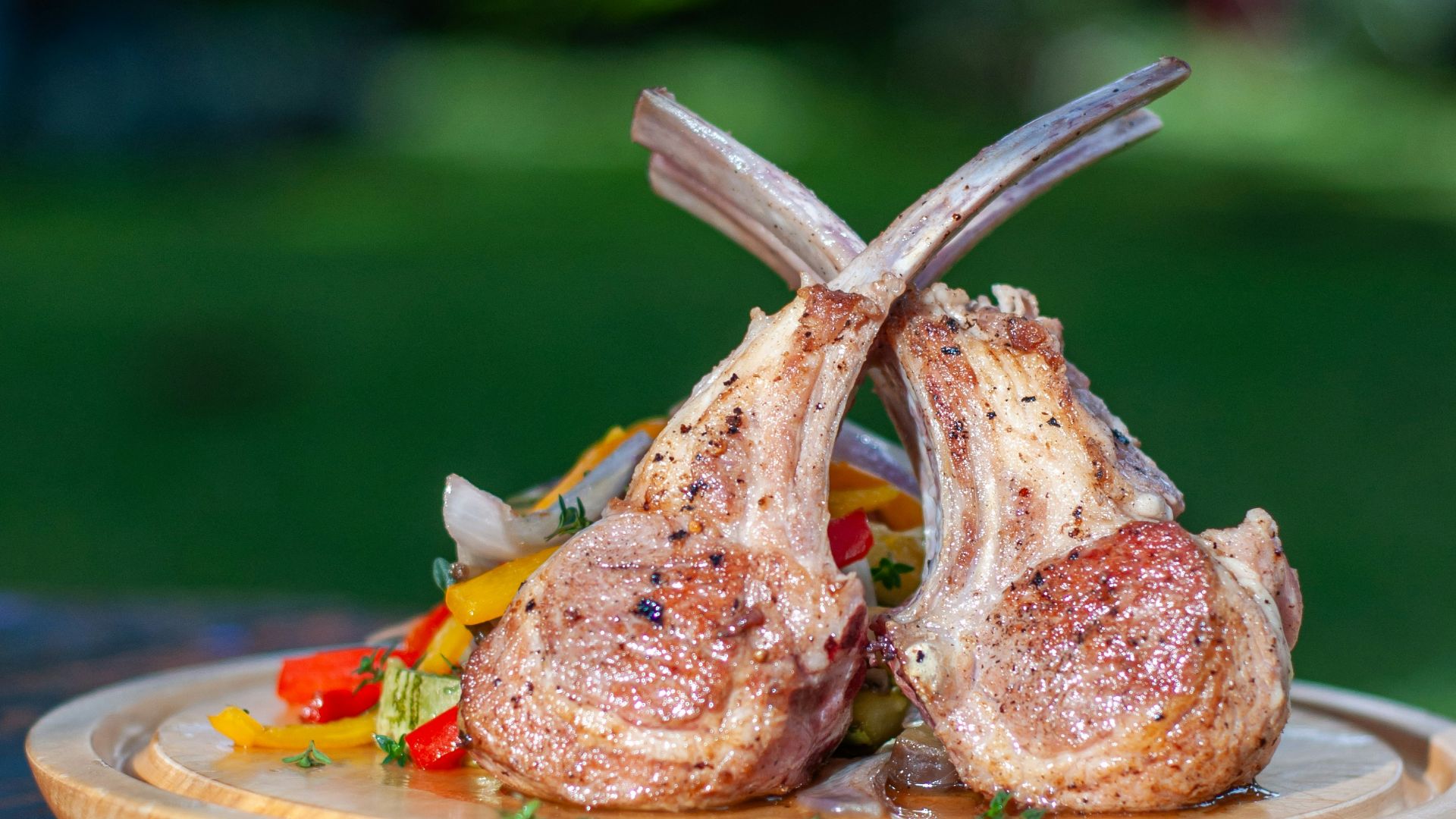 a wooden plate topped with meat on top of a wooden table