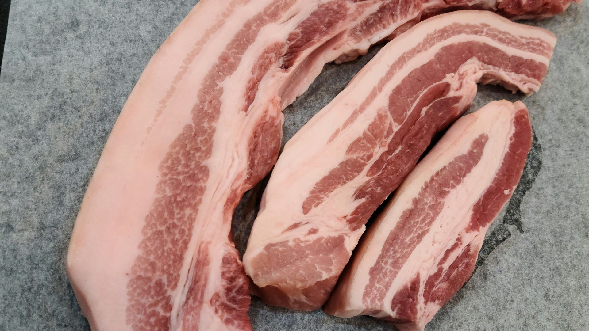 a pile of raw meat sitting on top of a cutting board