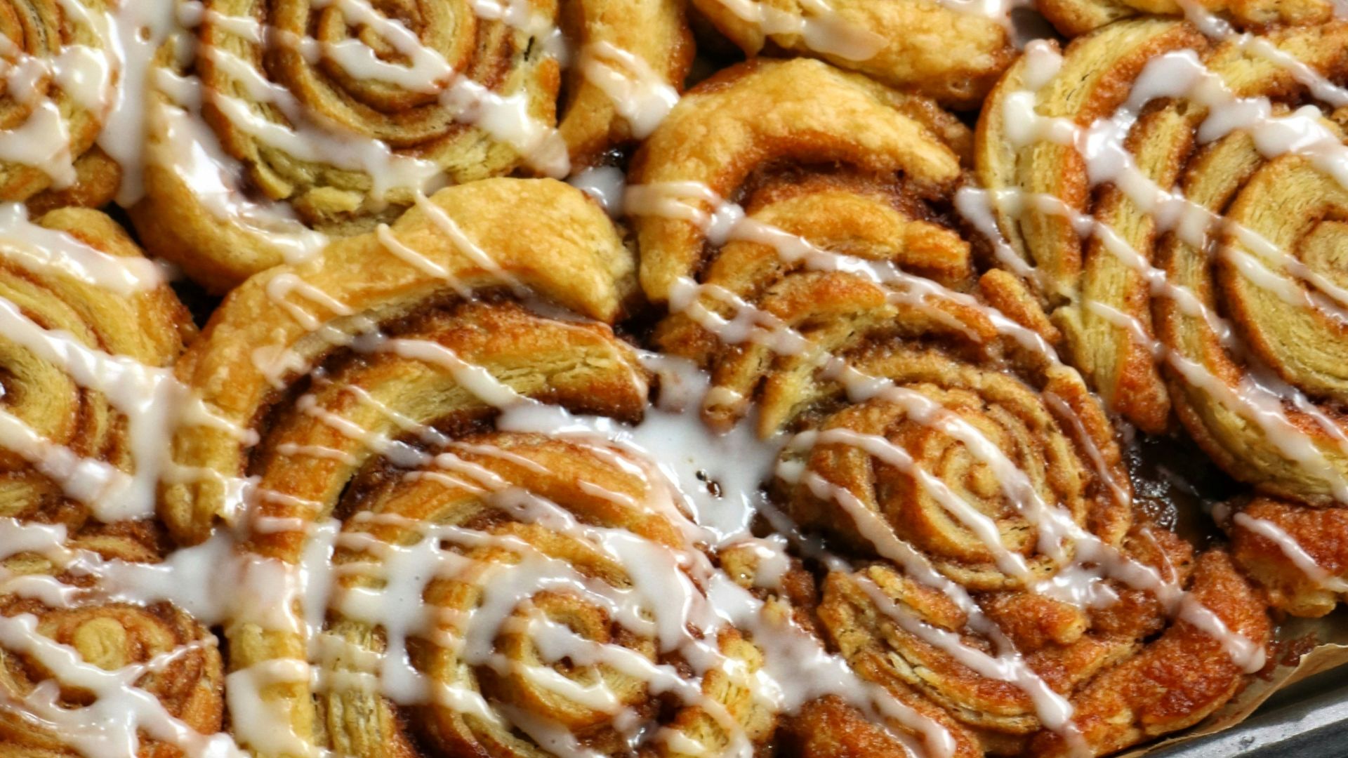 a pan filled with cinnamon rolls covered in icing