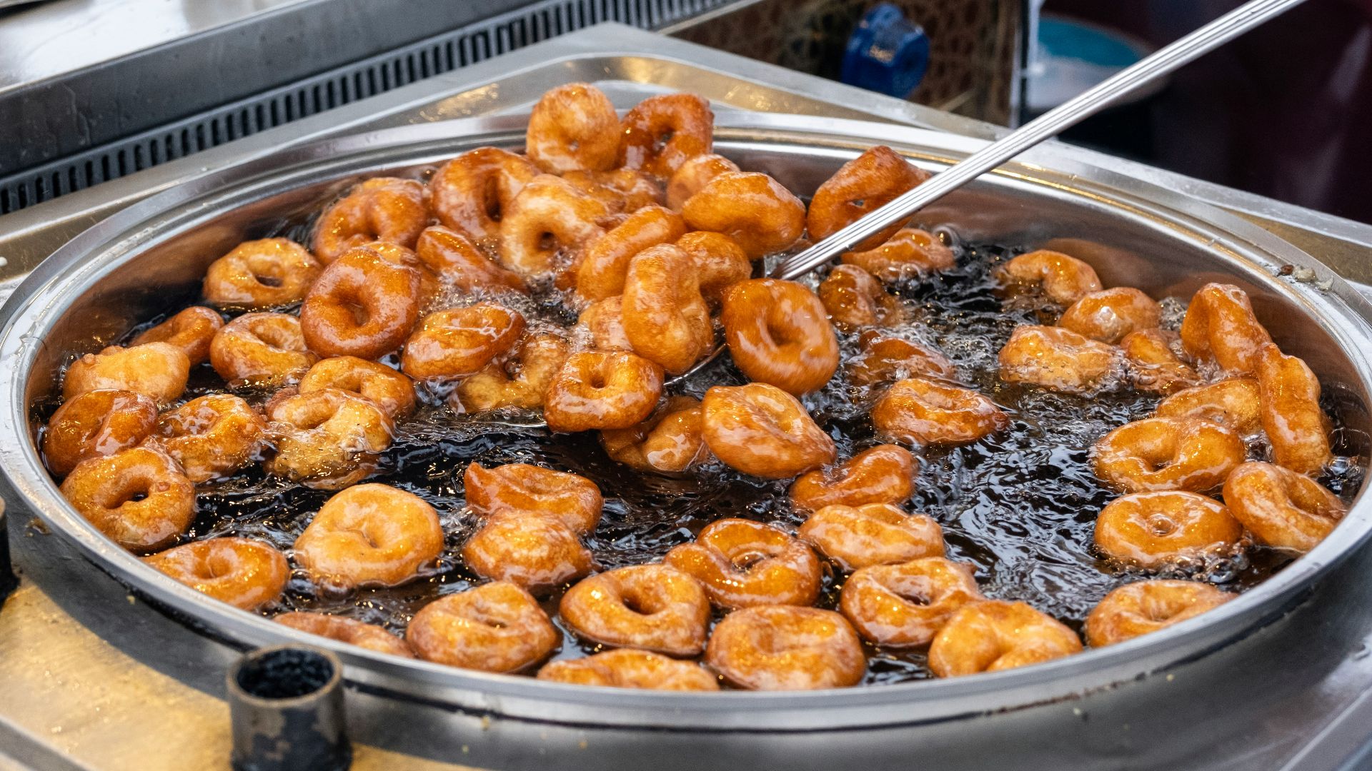 a frying pan filled with fried donuts on top of a stove