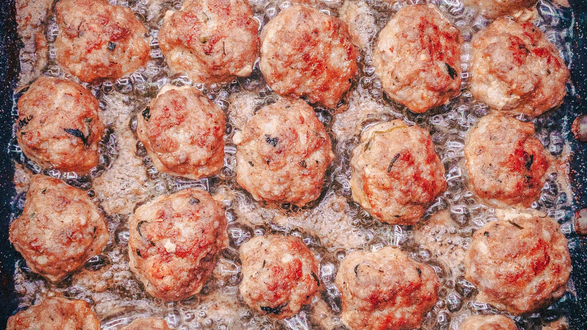 a pan filled with meatballs covered in sauce