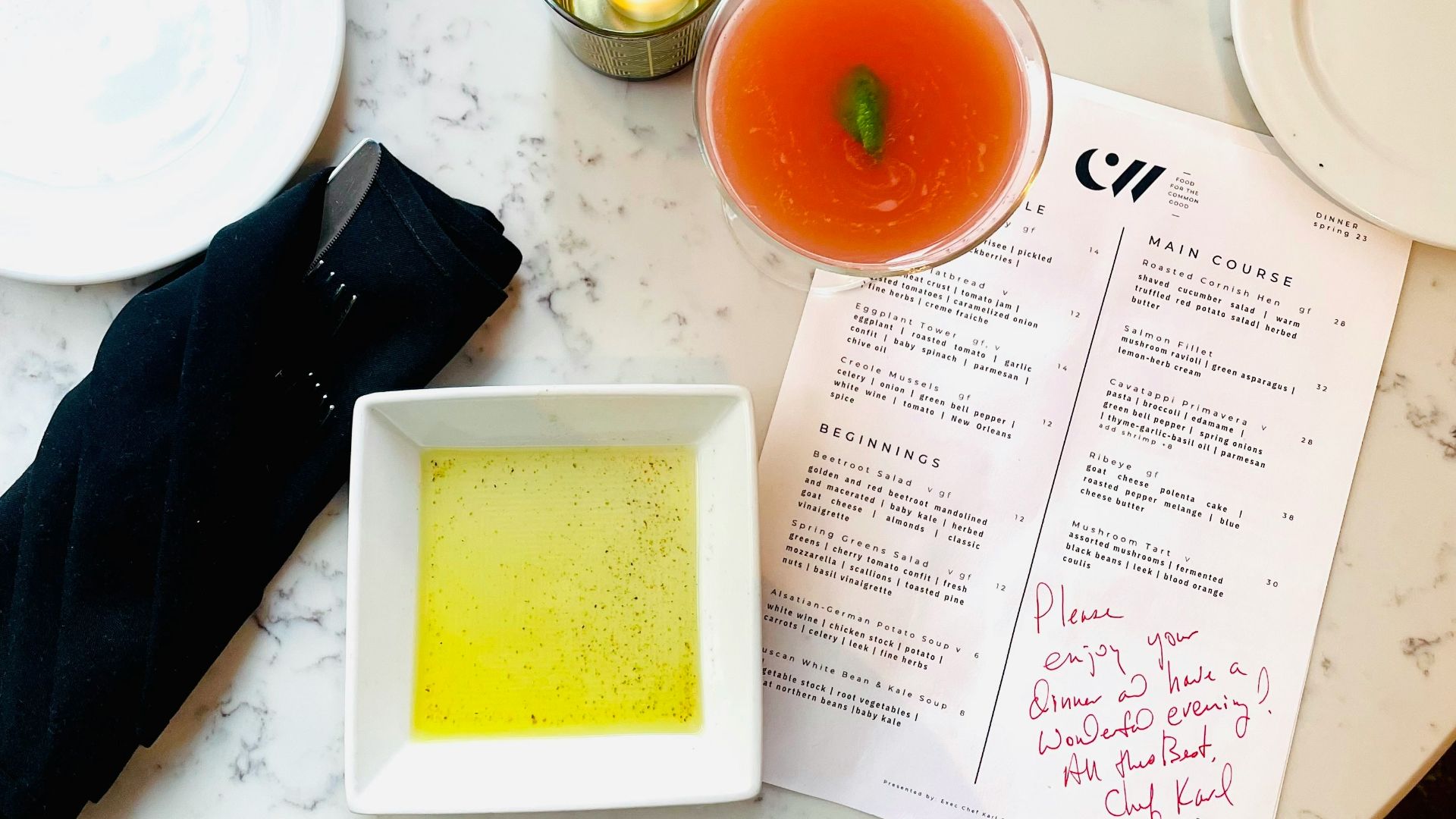 Cocktails, bread, and menu items displayed on a table.