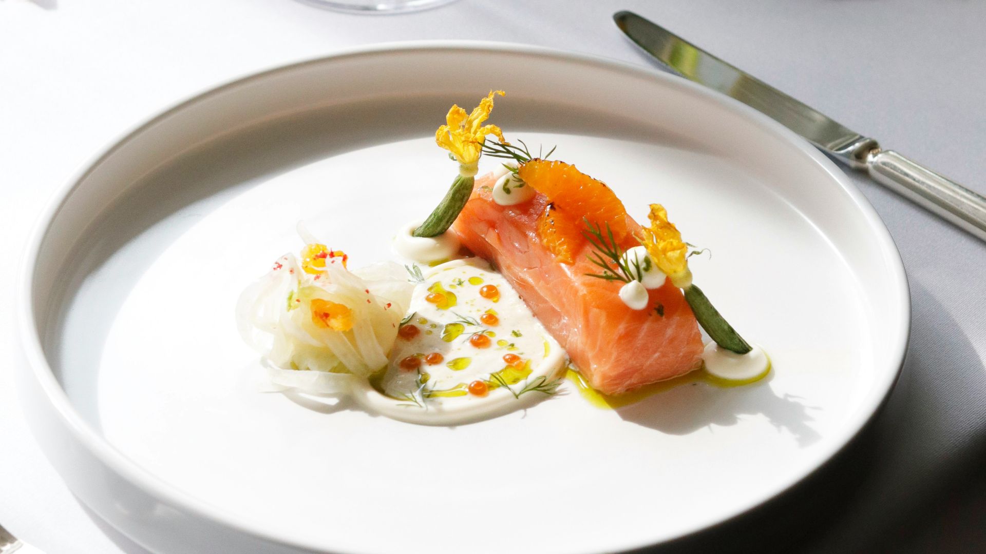 a white plate topped with food next to a glass of wine