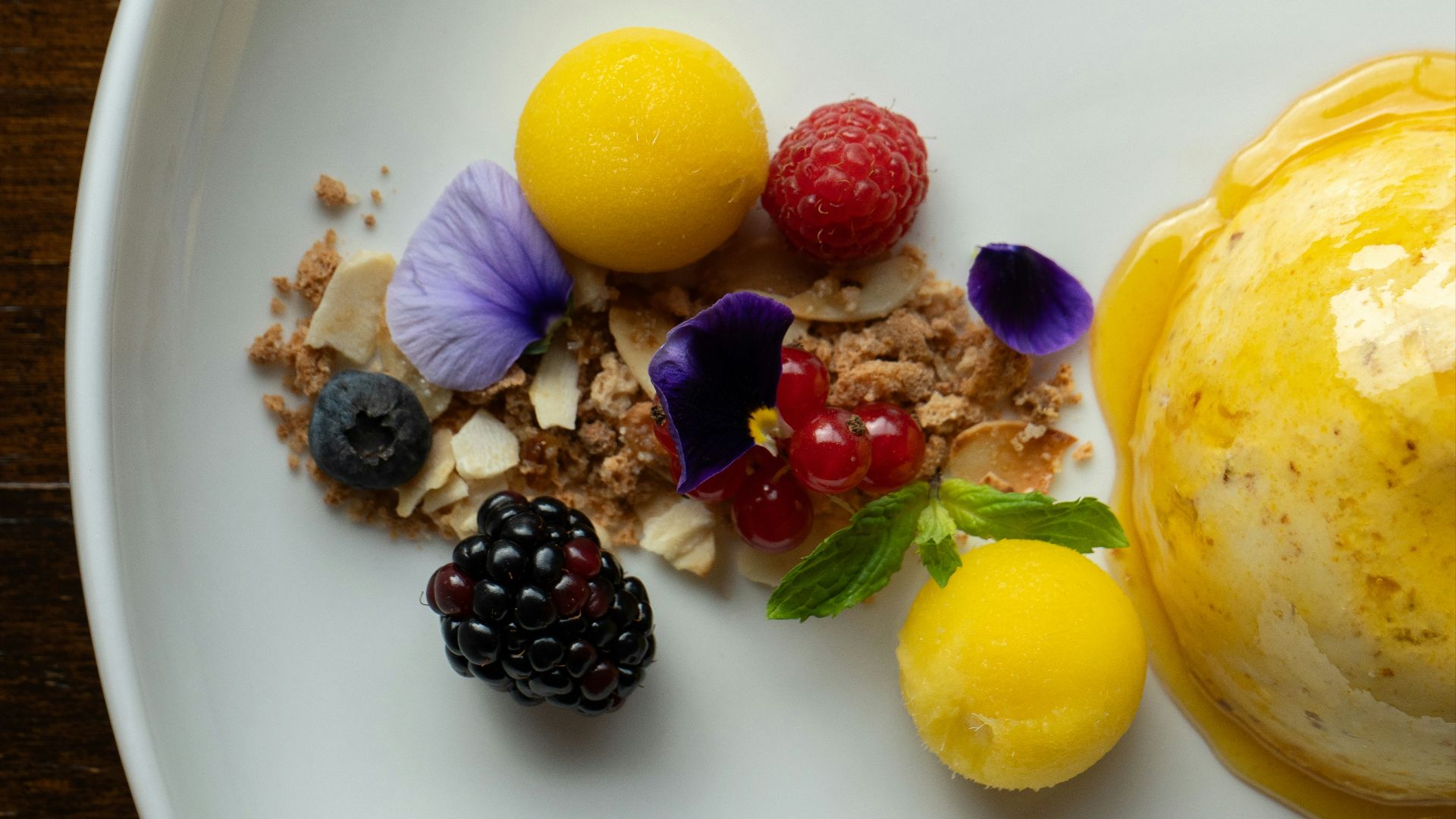 a white plate topped with fruit and a scoop of ice cream