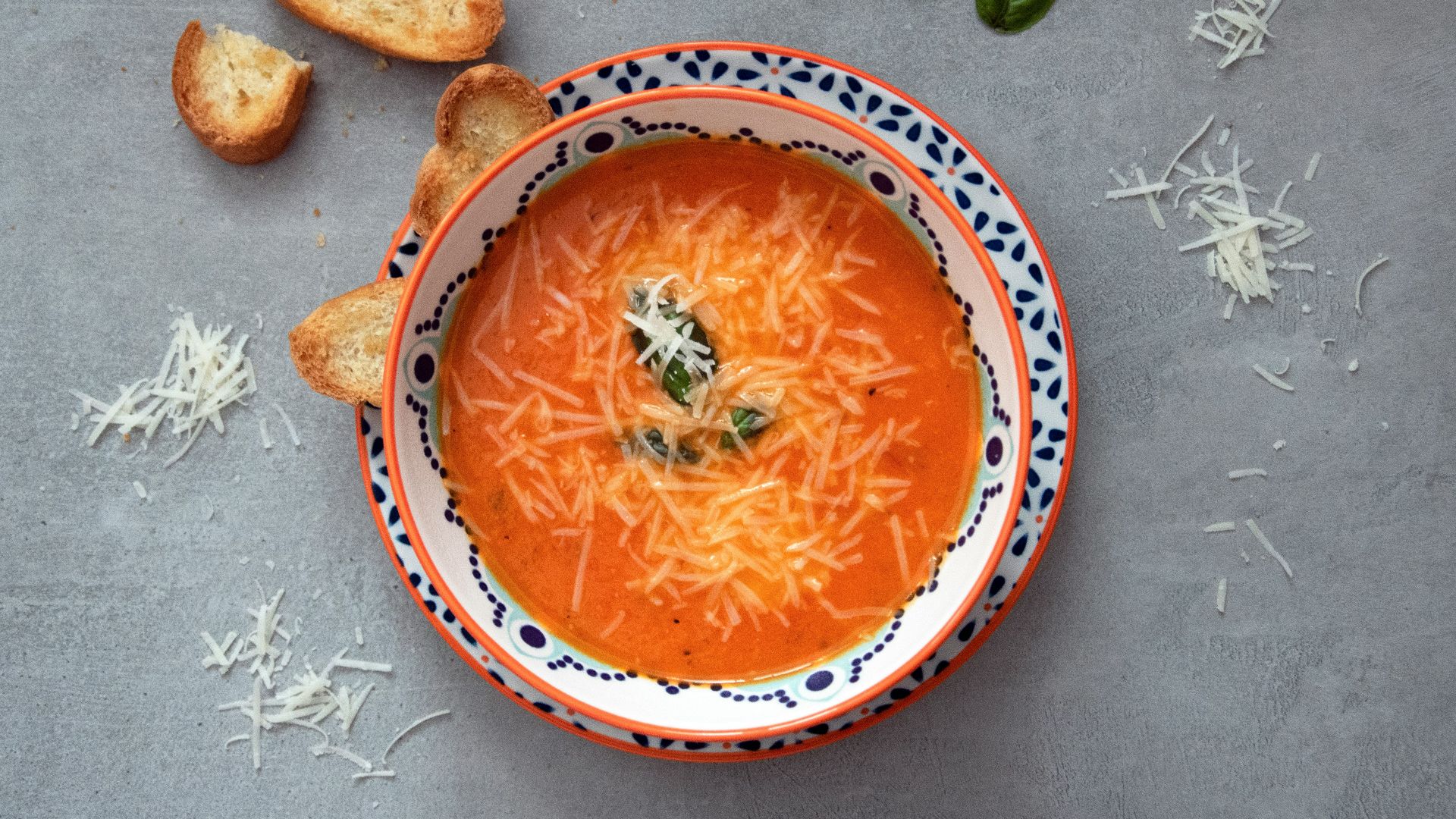 orange soup on white and blue ceramic bowl