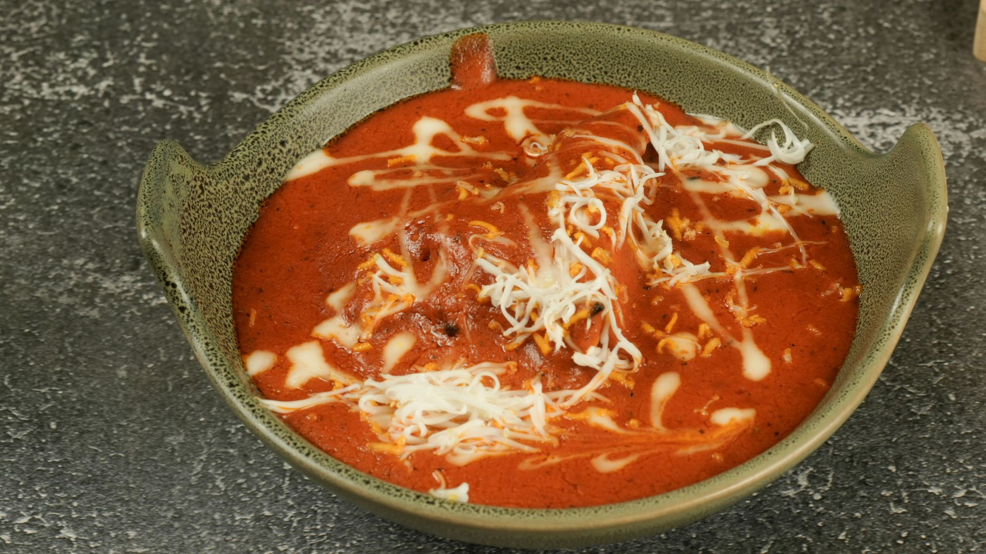 Tomato soup with cheese in a bowl.