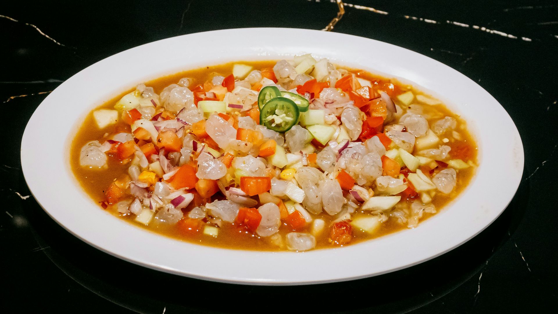 A white plate topped with a stew of vegetables