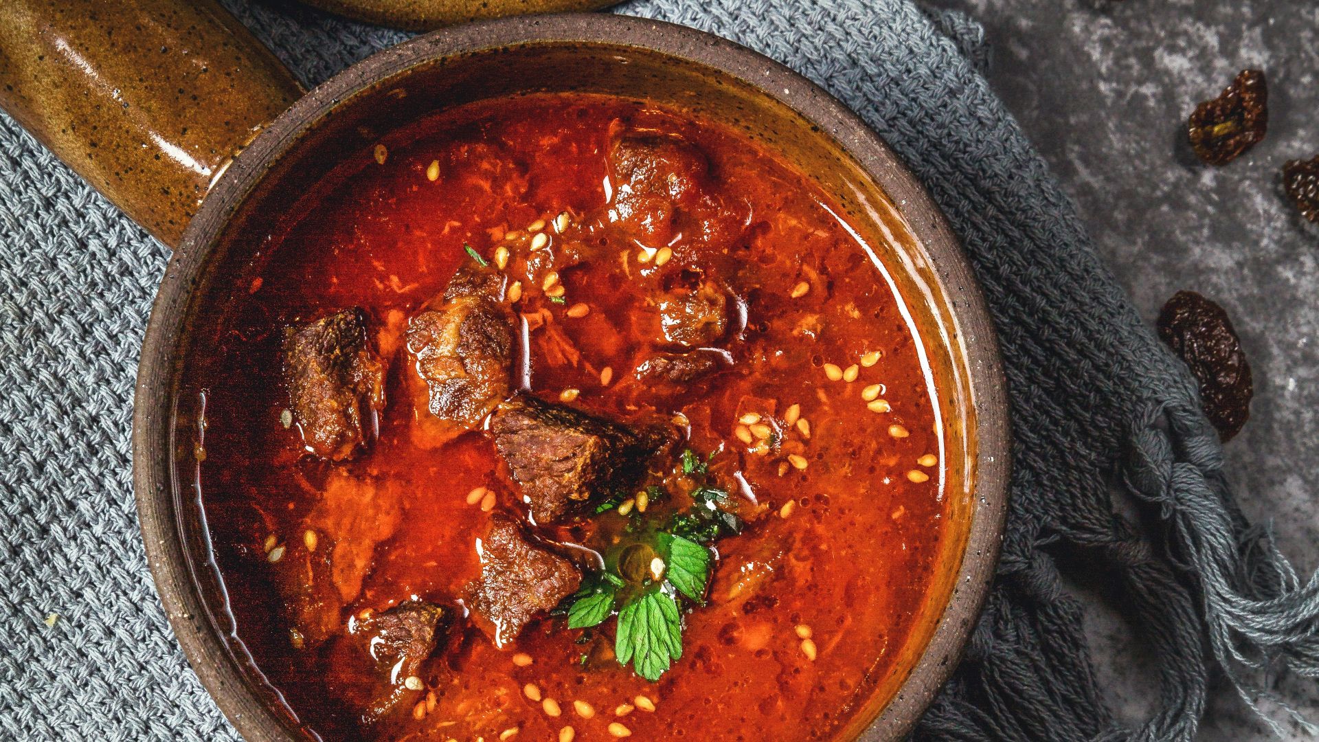 skewed meat in bowl beside knife and fork