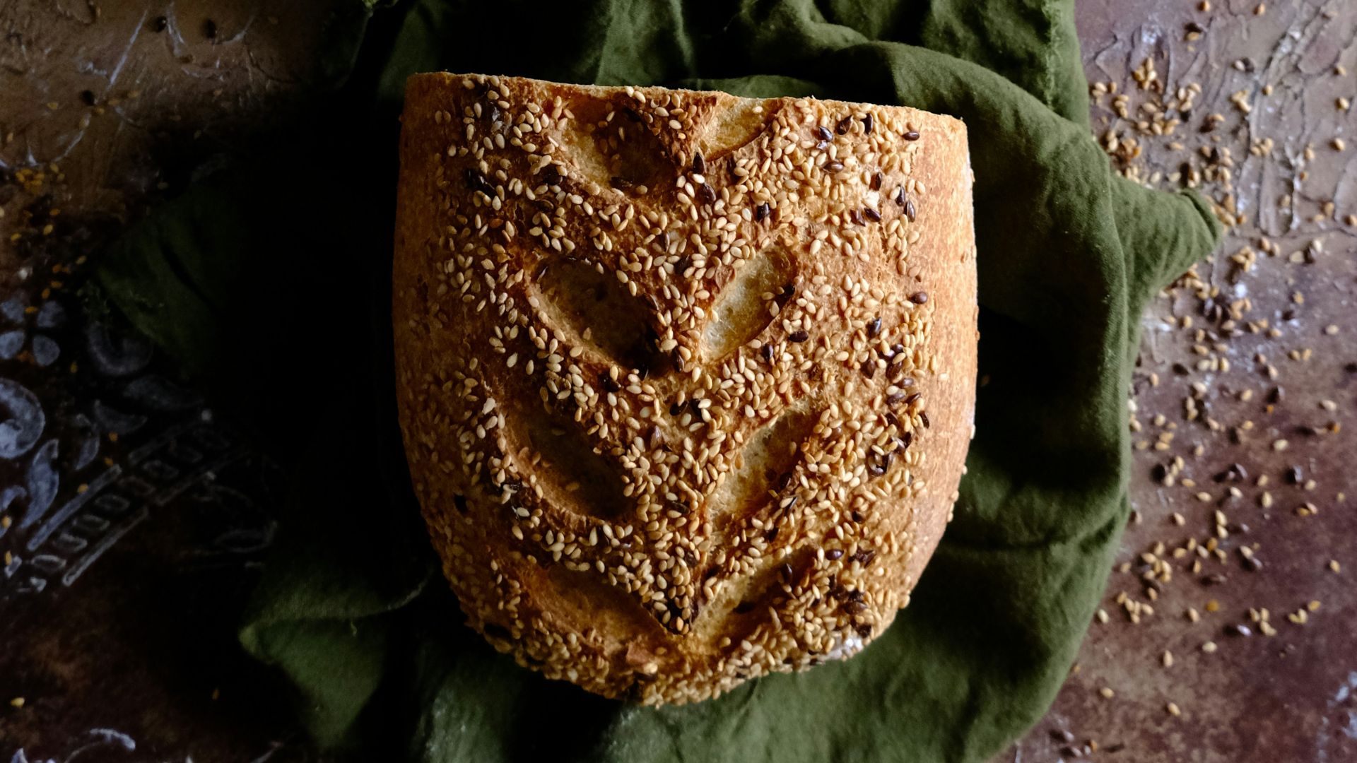 a wooden bowl filled with bread next to a loaf of bread