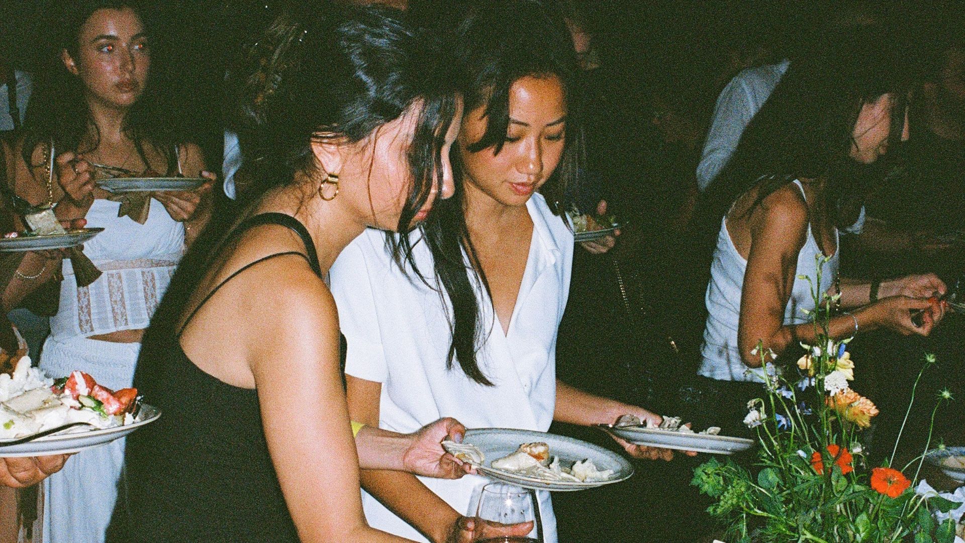 Guests serve themselves from a bountiful party table.