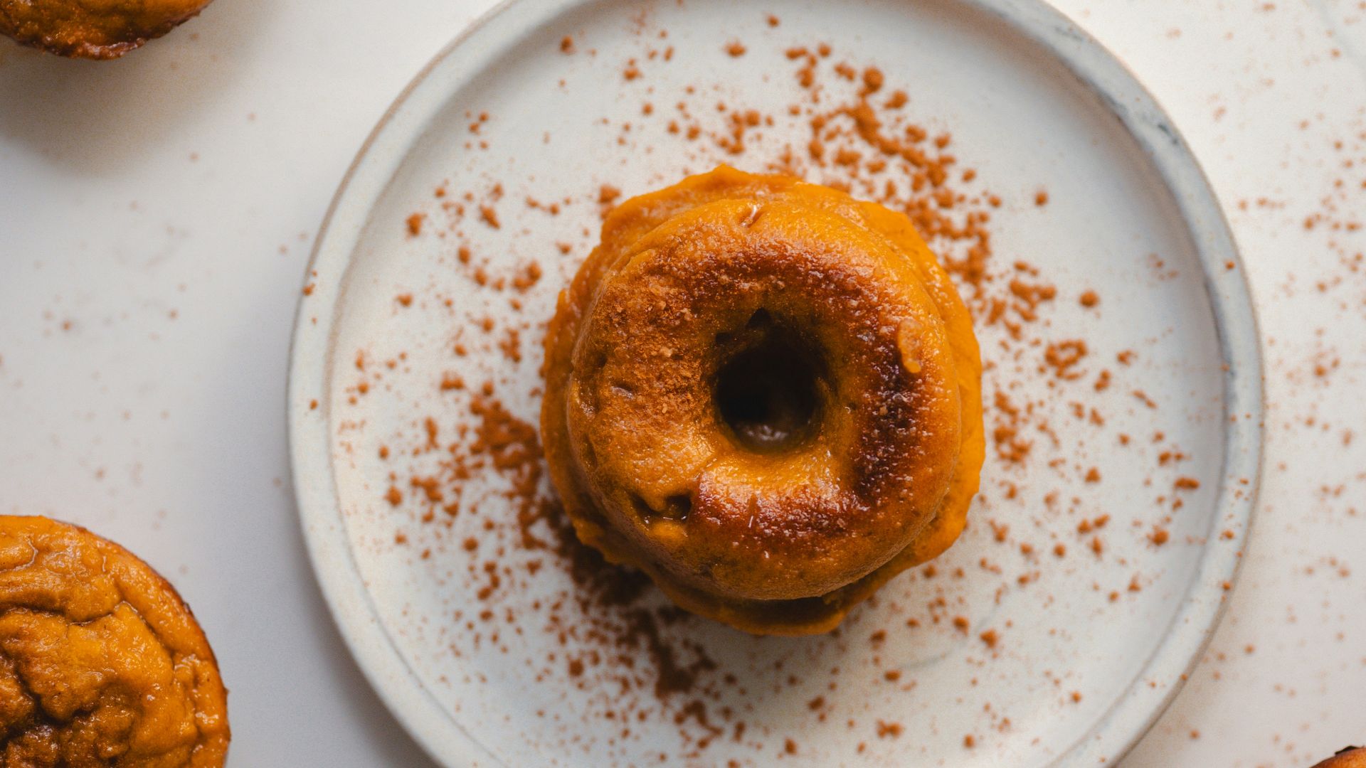 a white plate topped with a donut covered in powdered sugar