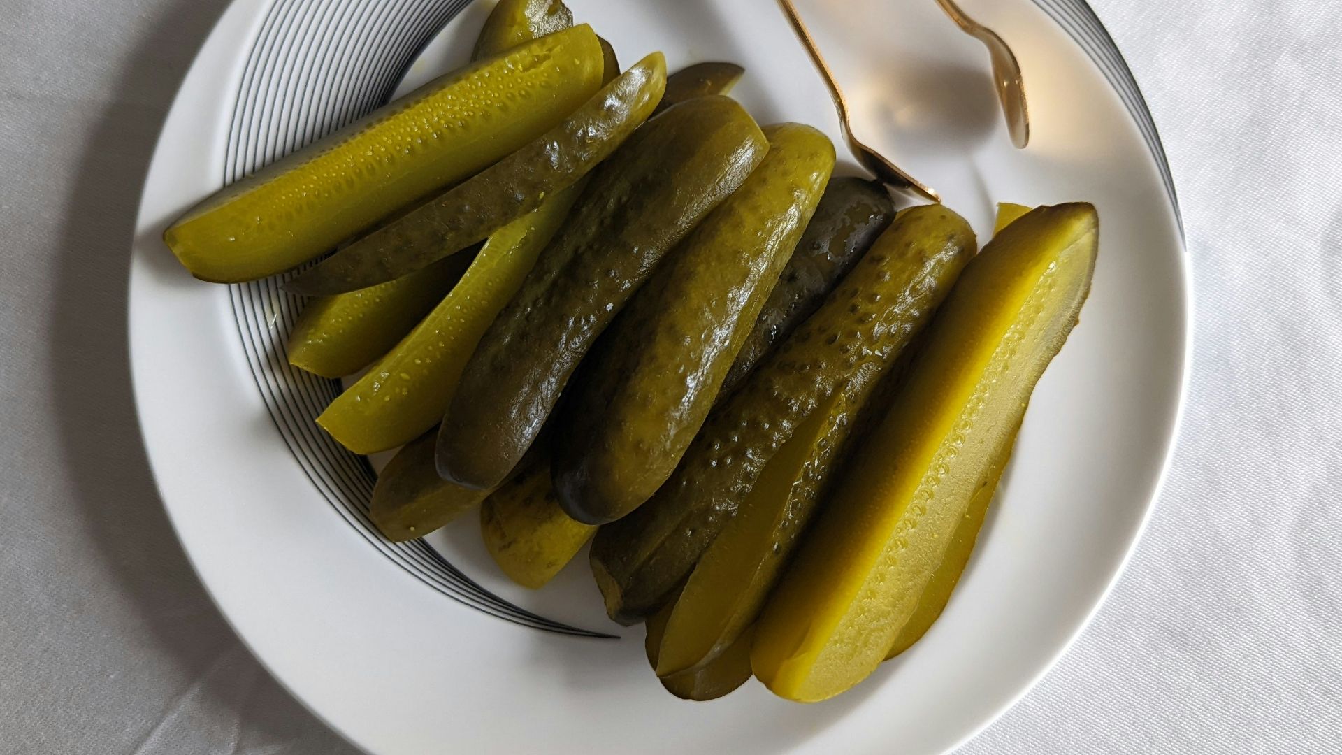 a white plate topped with pickles next to a fork