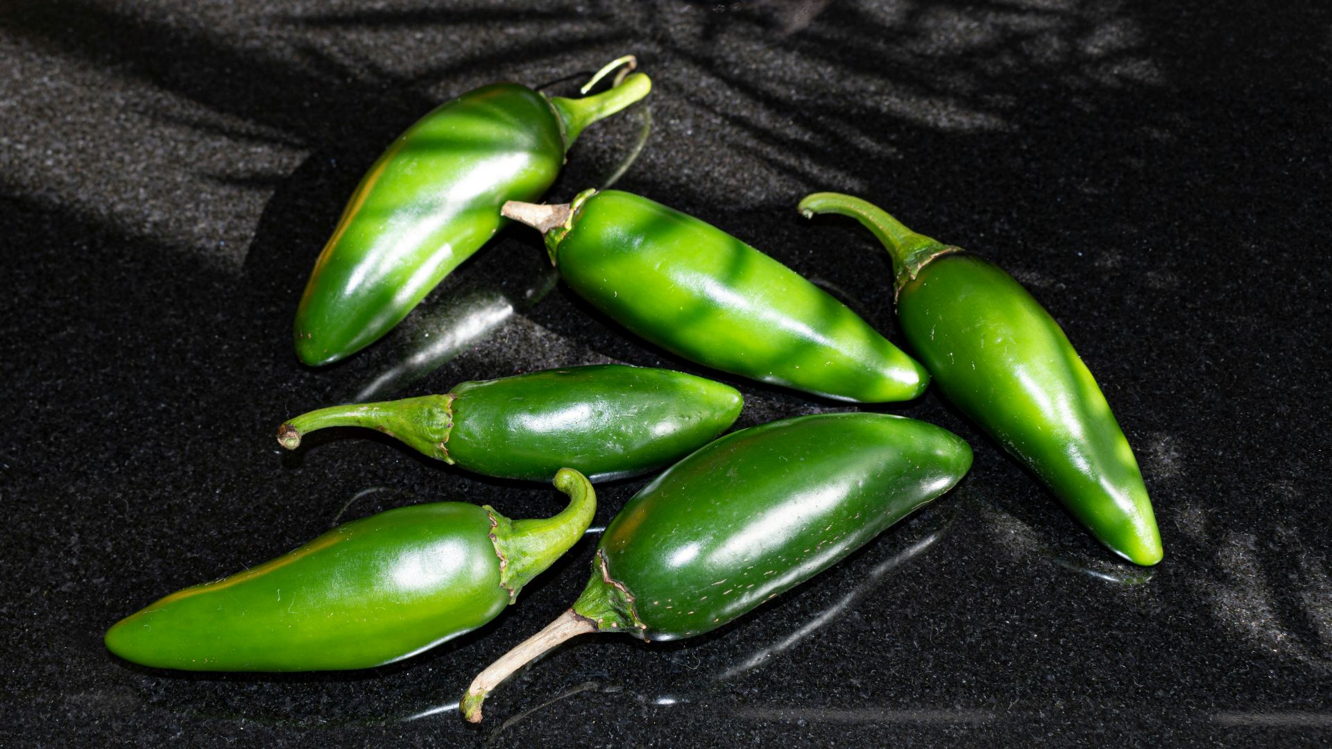 a group of green peppers sitting on top of a counter