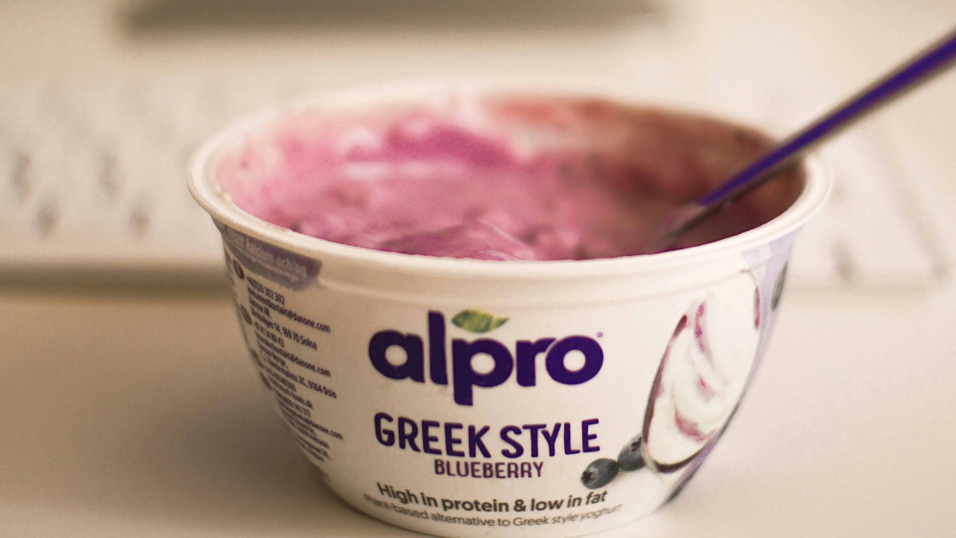 a bowl of greek style yogurt sitting in front of a computer