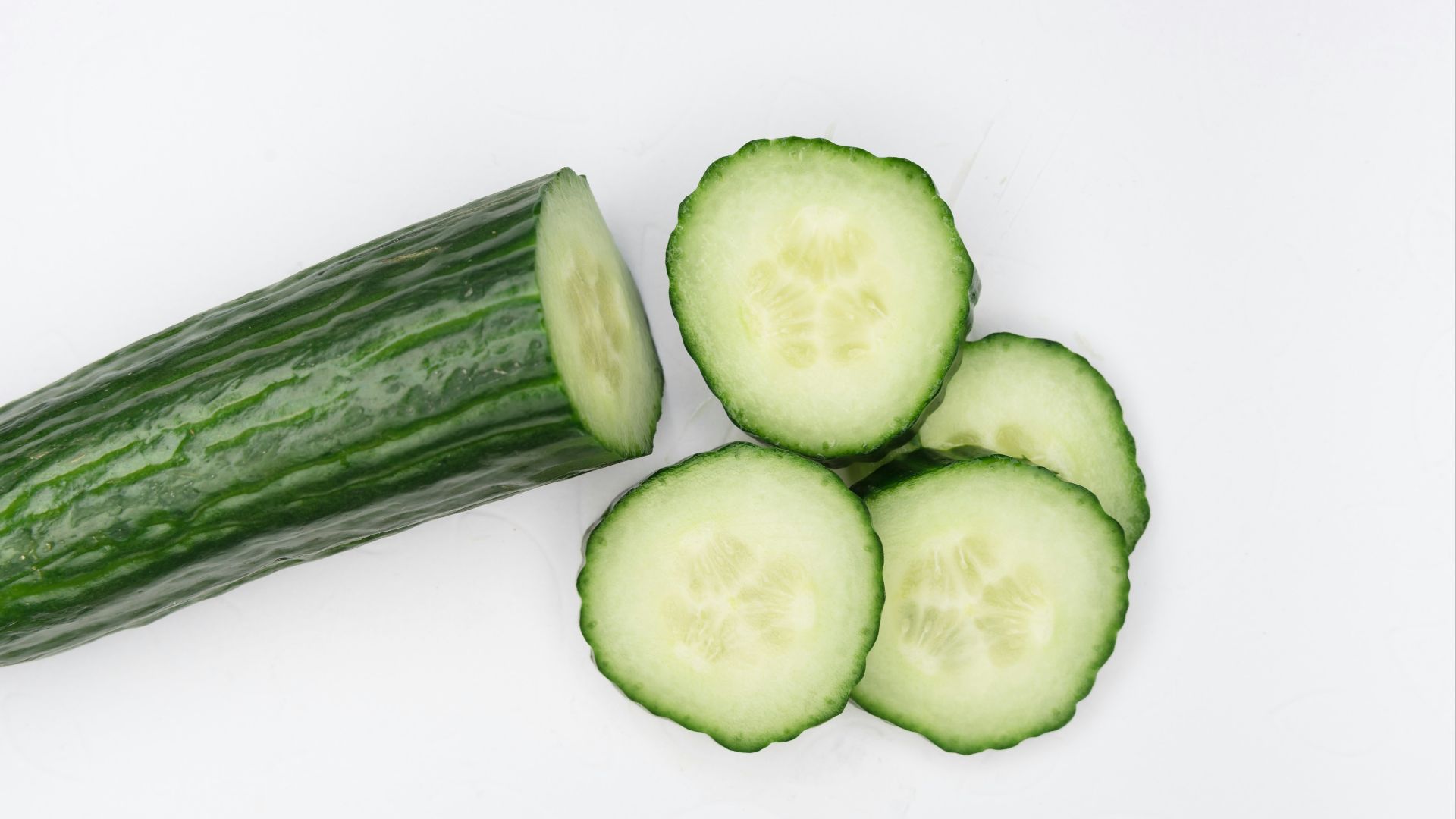 sliced cucumber on white surface