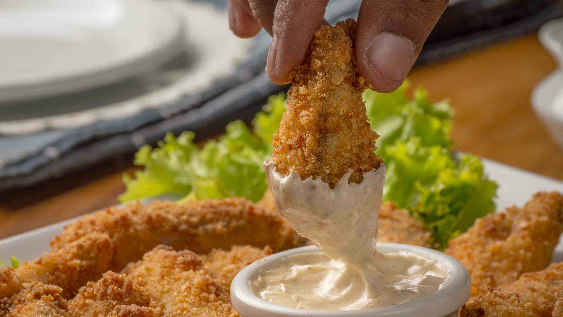 person dipping fried cuisine on dip
