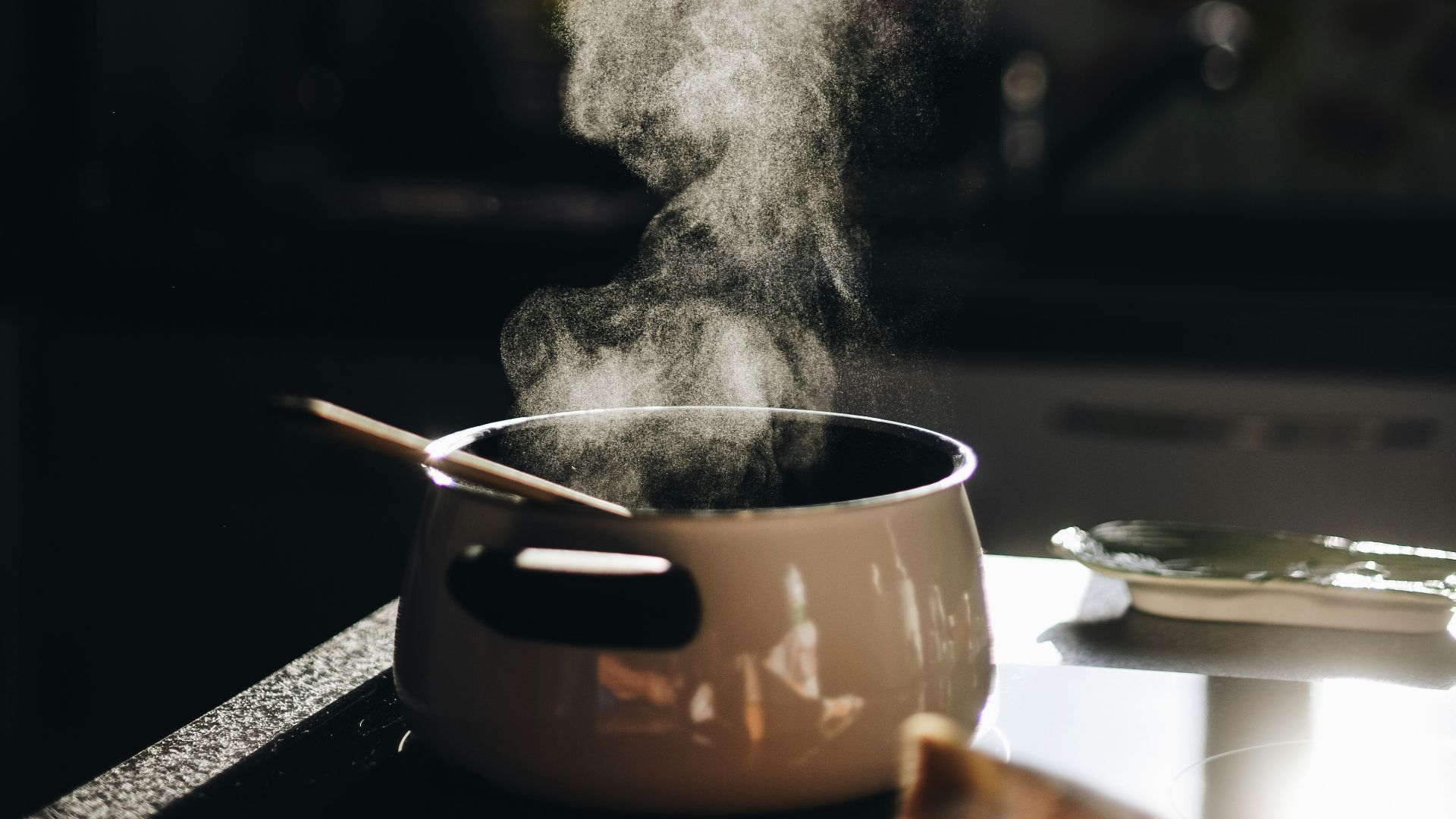 white casserole with gray spoon on black surface
