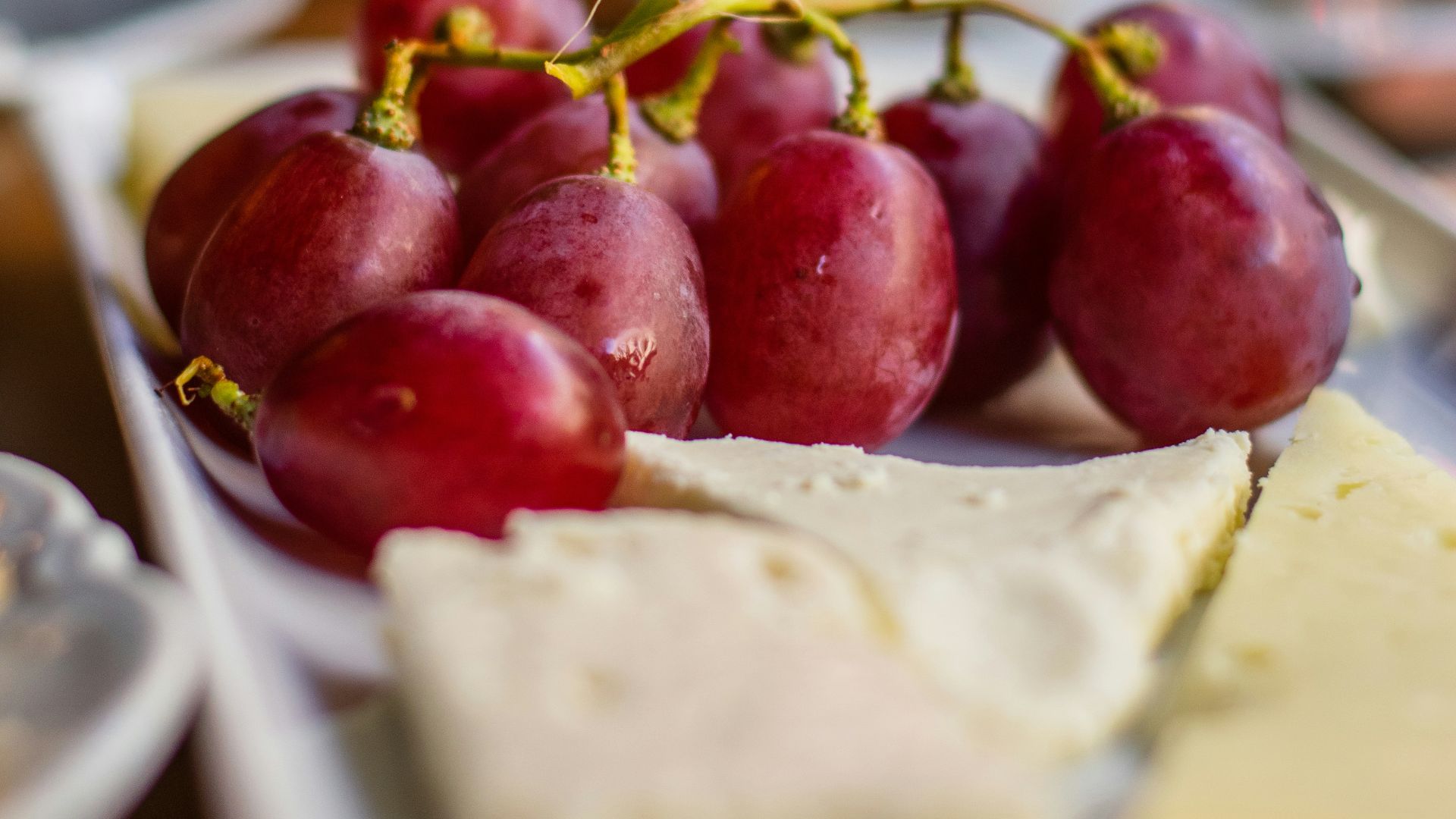 a plate of grapes and cheese on a table