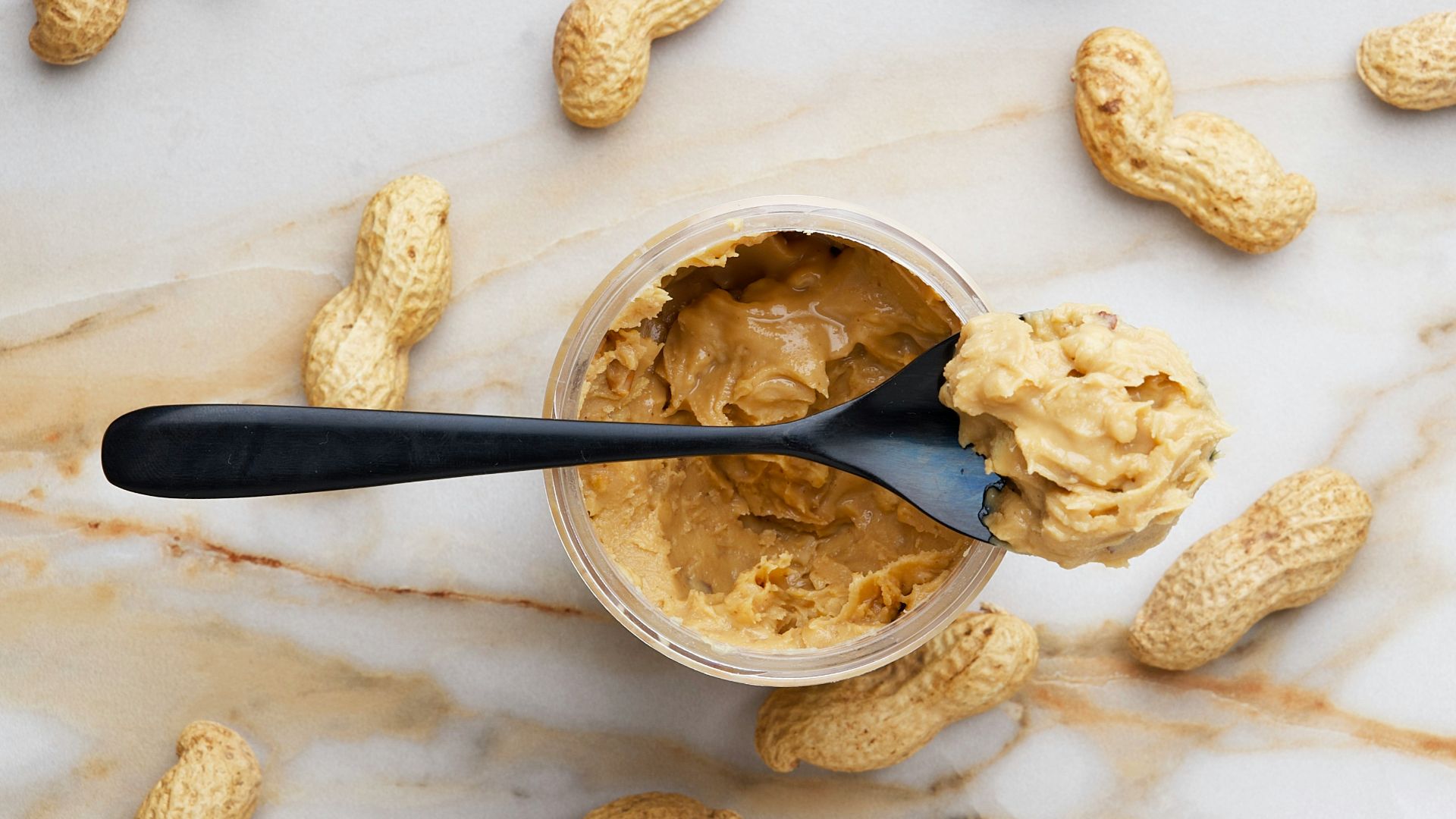 peanut butter with black spoon
