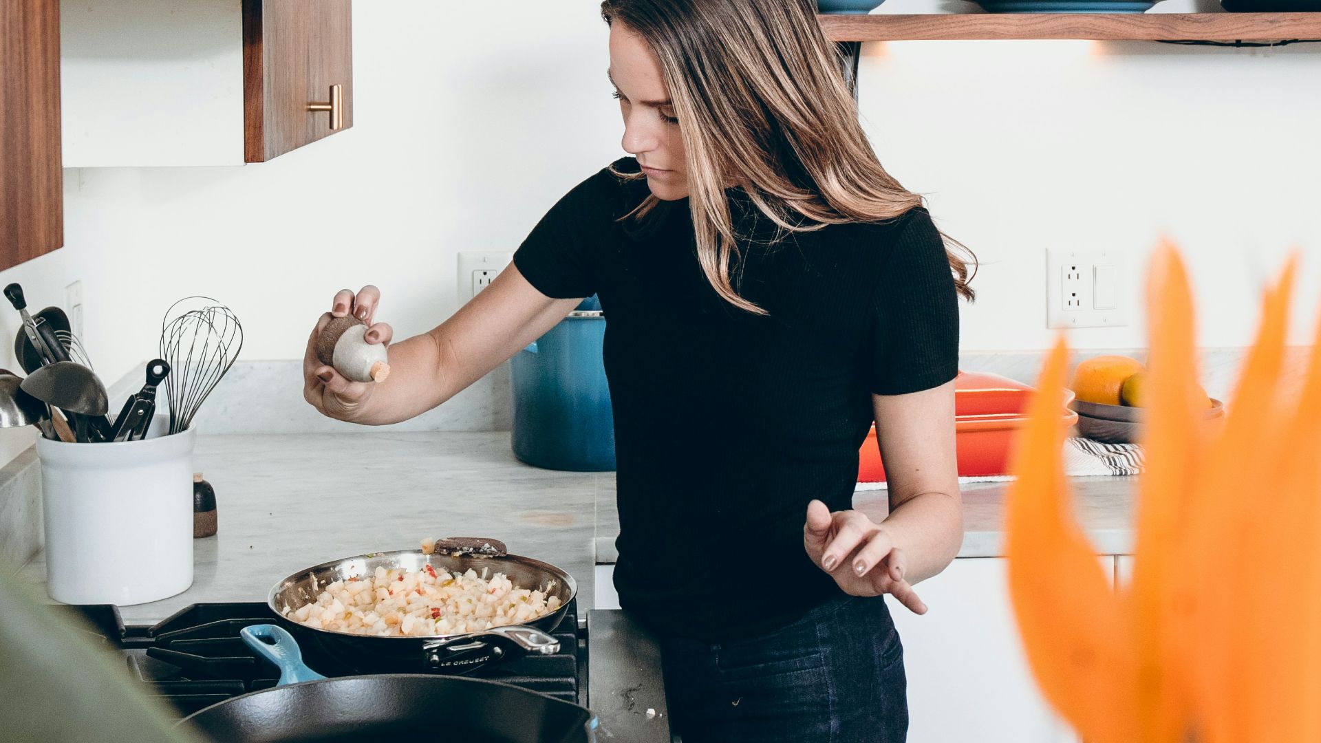 woman standing in front of freestanding range oven