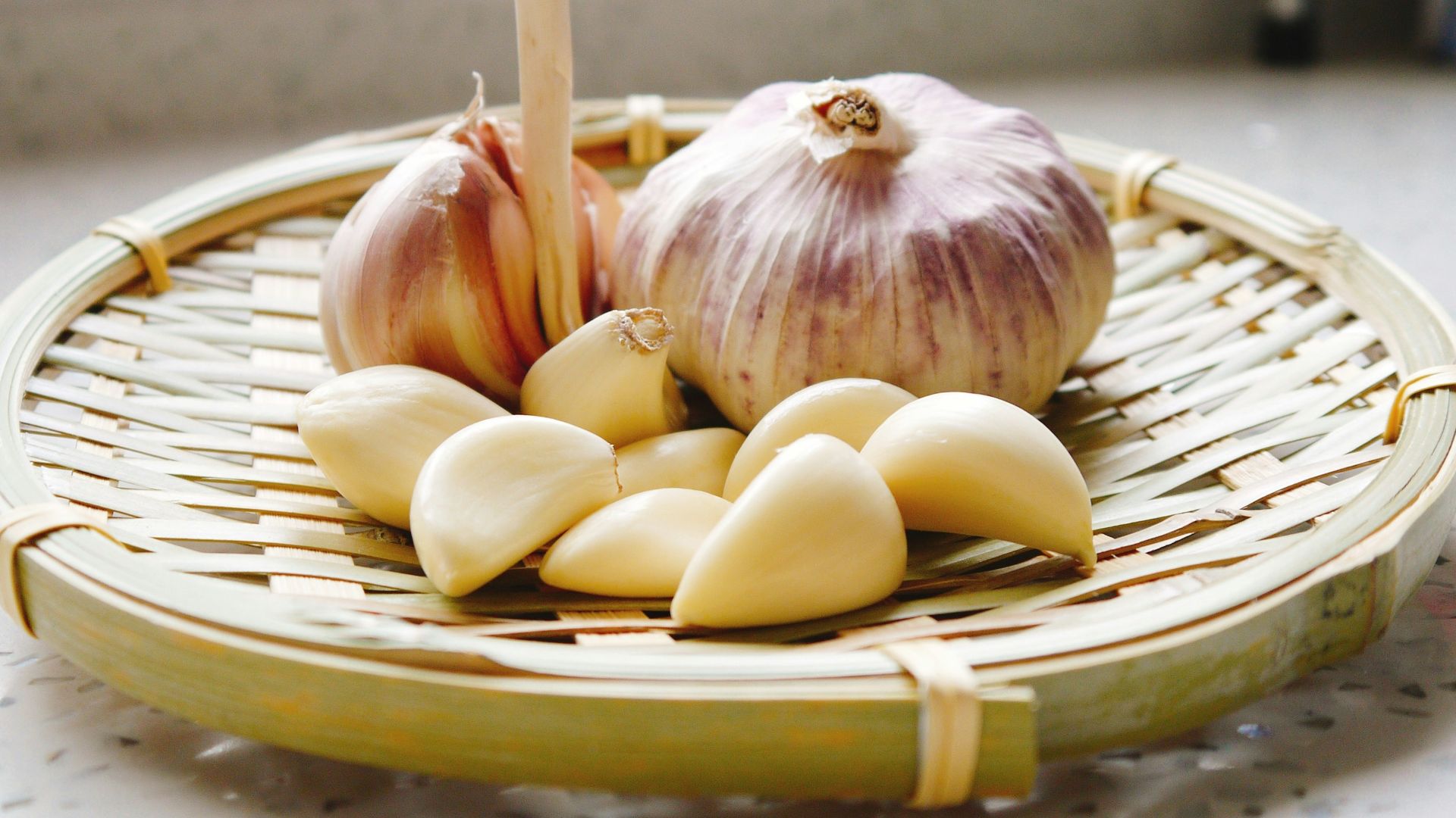 a basket of garlic and garlic bulbs on a counter
