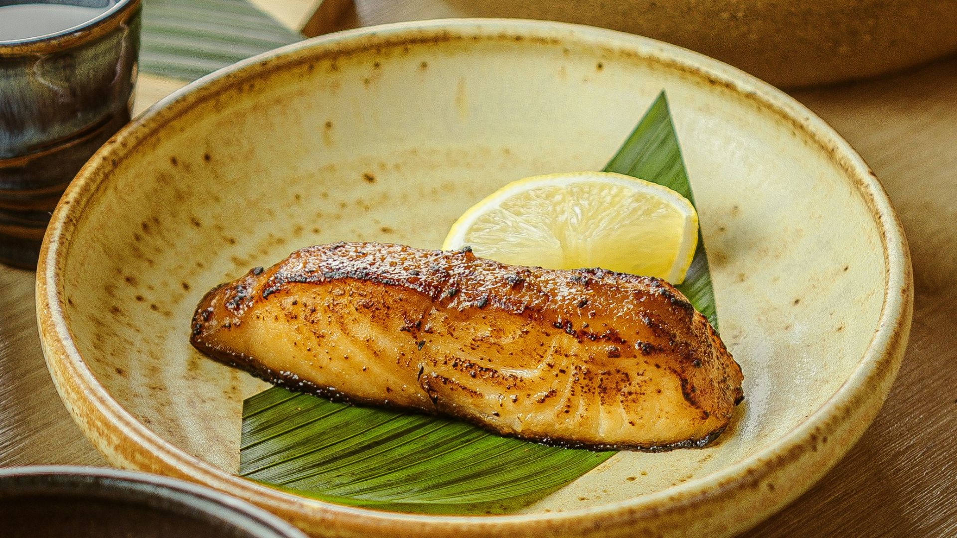 a wooden table topped with bowls filled with food