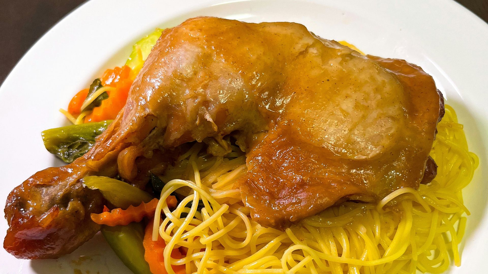 a white plate topped with spaghetti and meat