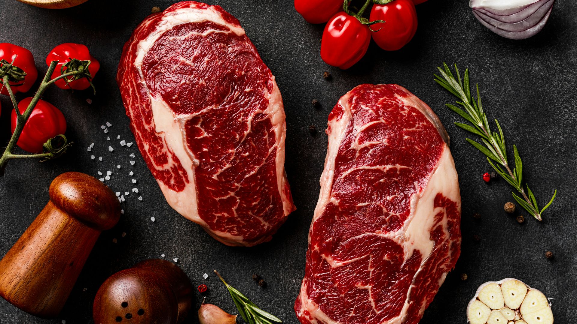 a couple of steaks sitting on top of a table
