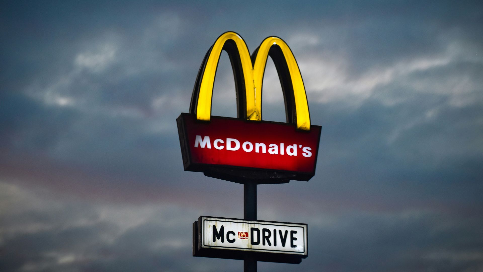 a mcdonald's sign with a cloudy sky in the background