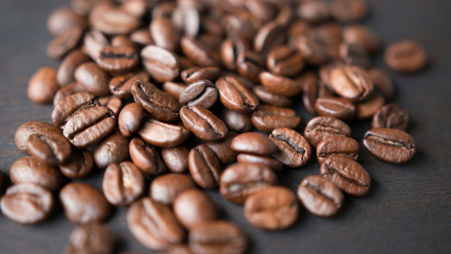 brown coffee beans on gray surface