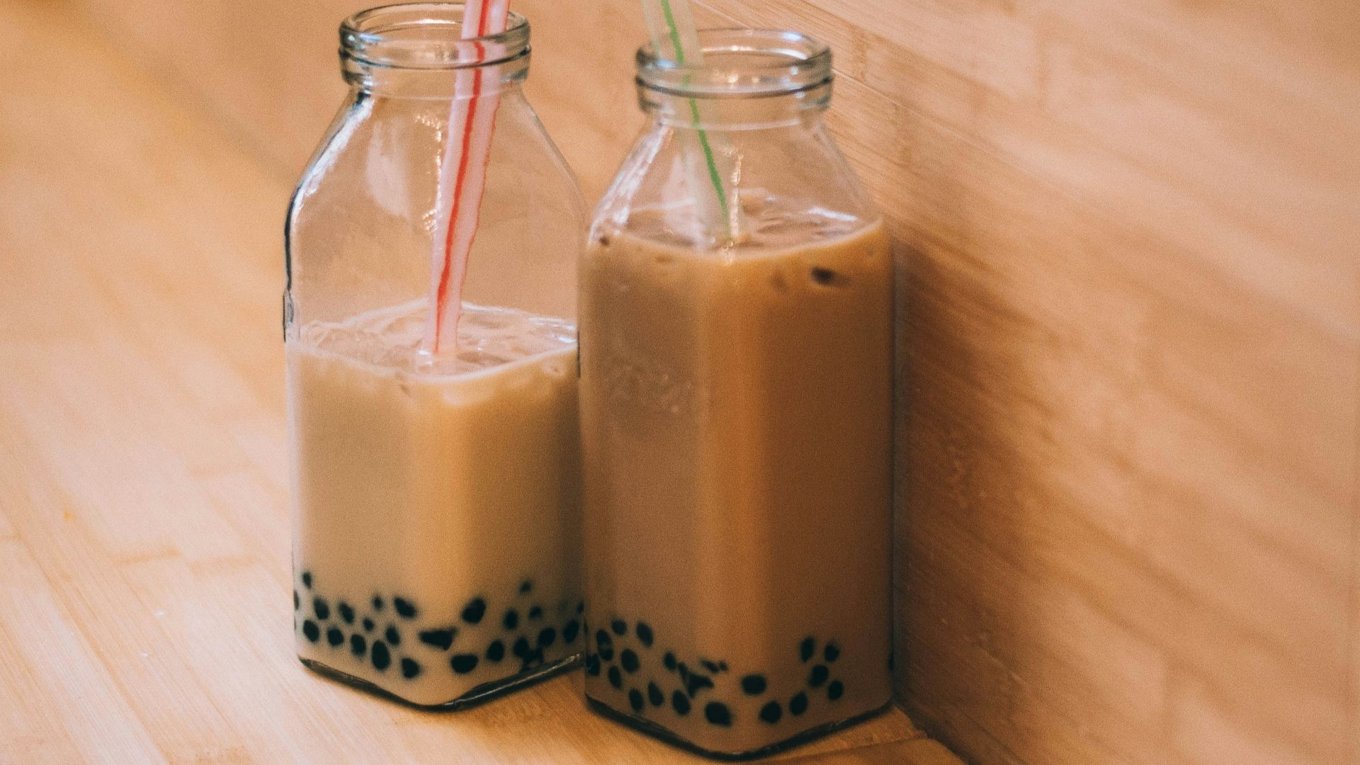 two clear glass jars with straws