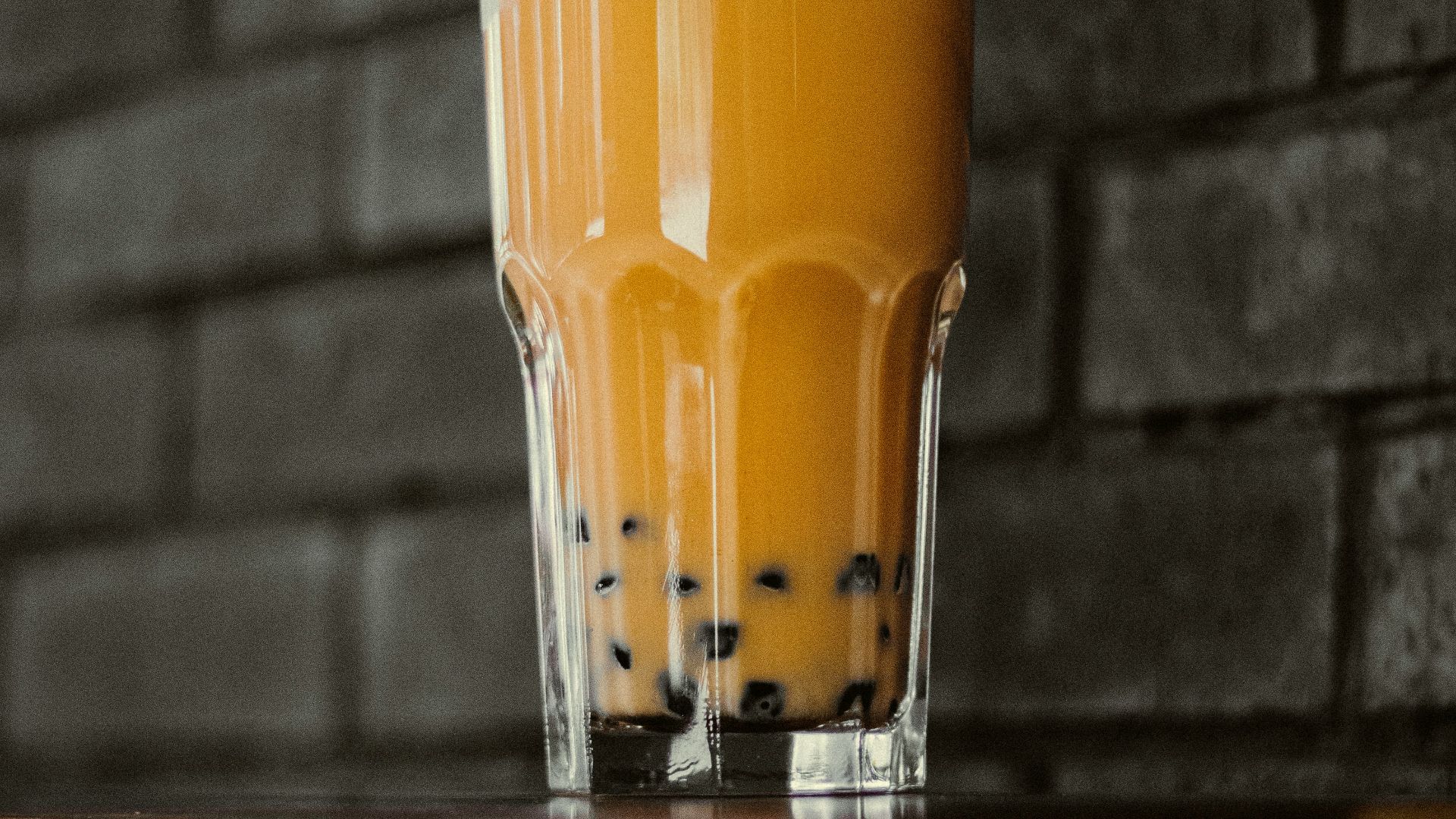 a glass of orange juice sitting on top of a table