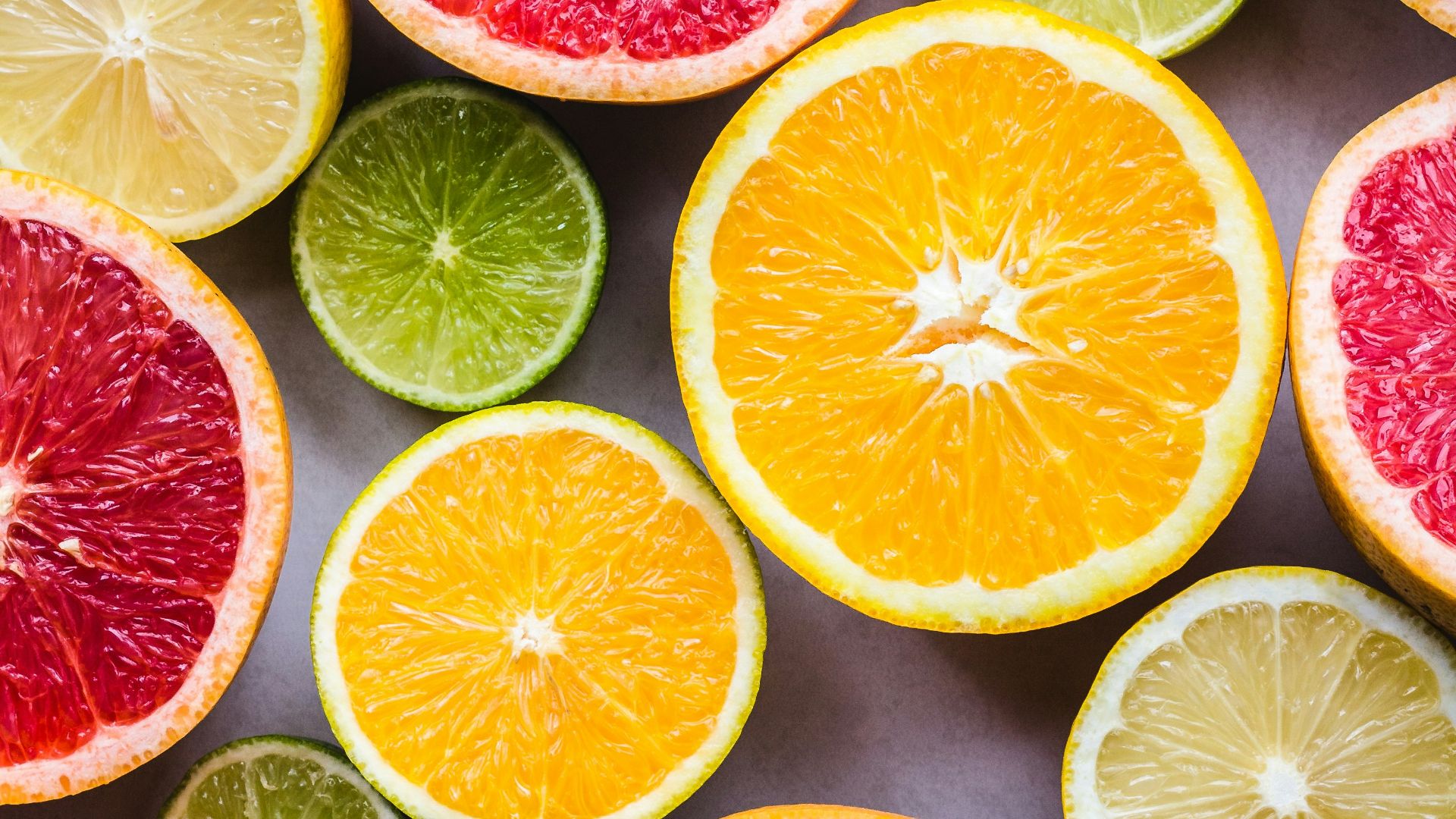 flat lay photography of sliced pomegranate, lime, and lemon