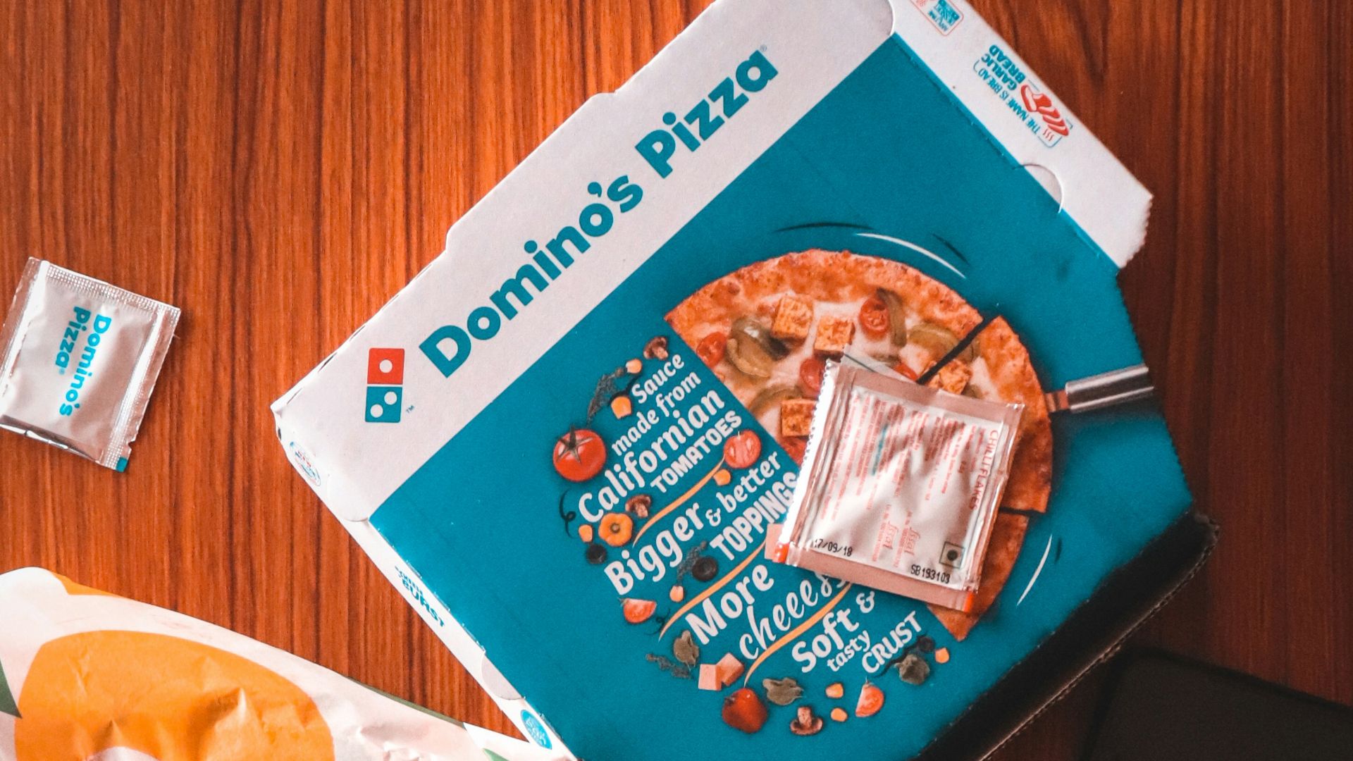 pizza and sauce packs beside iPhone on table